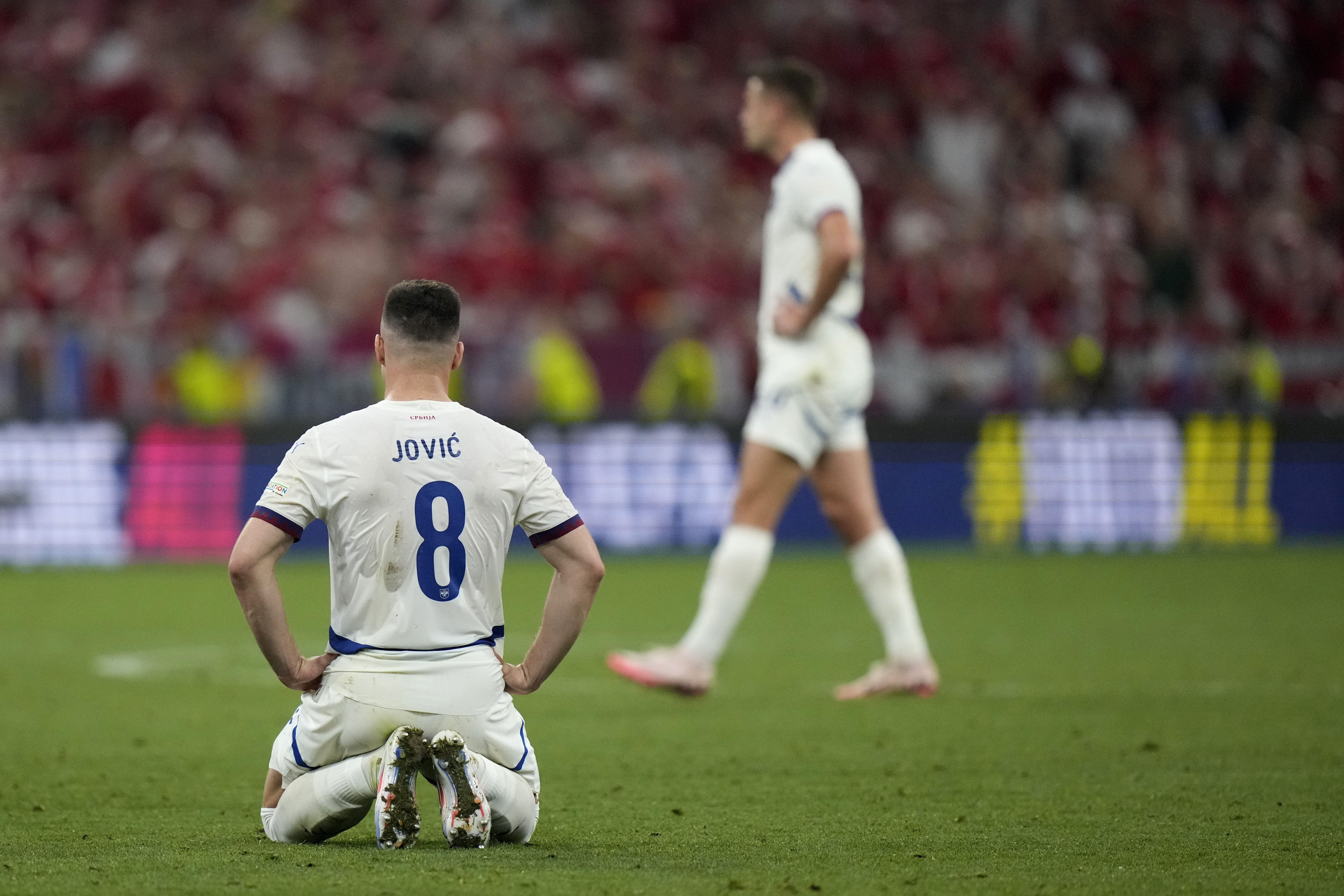 Serbia's Luka Jovic, kneels on the pitch after a Group C match between Denmark and Serbia at the Euro 2024 soccer tournament in Munich, Germany, Tuesday, June 25, 2024. The match ended in a score of 0-0. (AP Photo/Matthias Schrader)