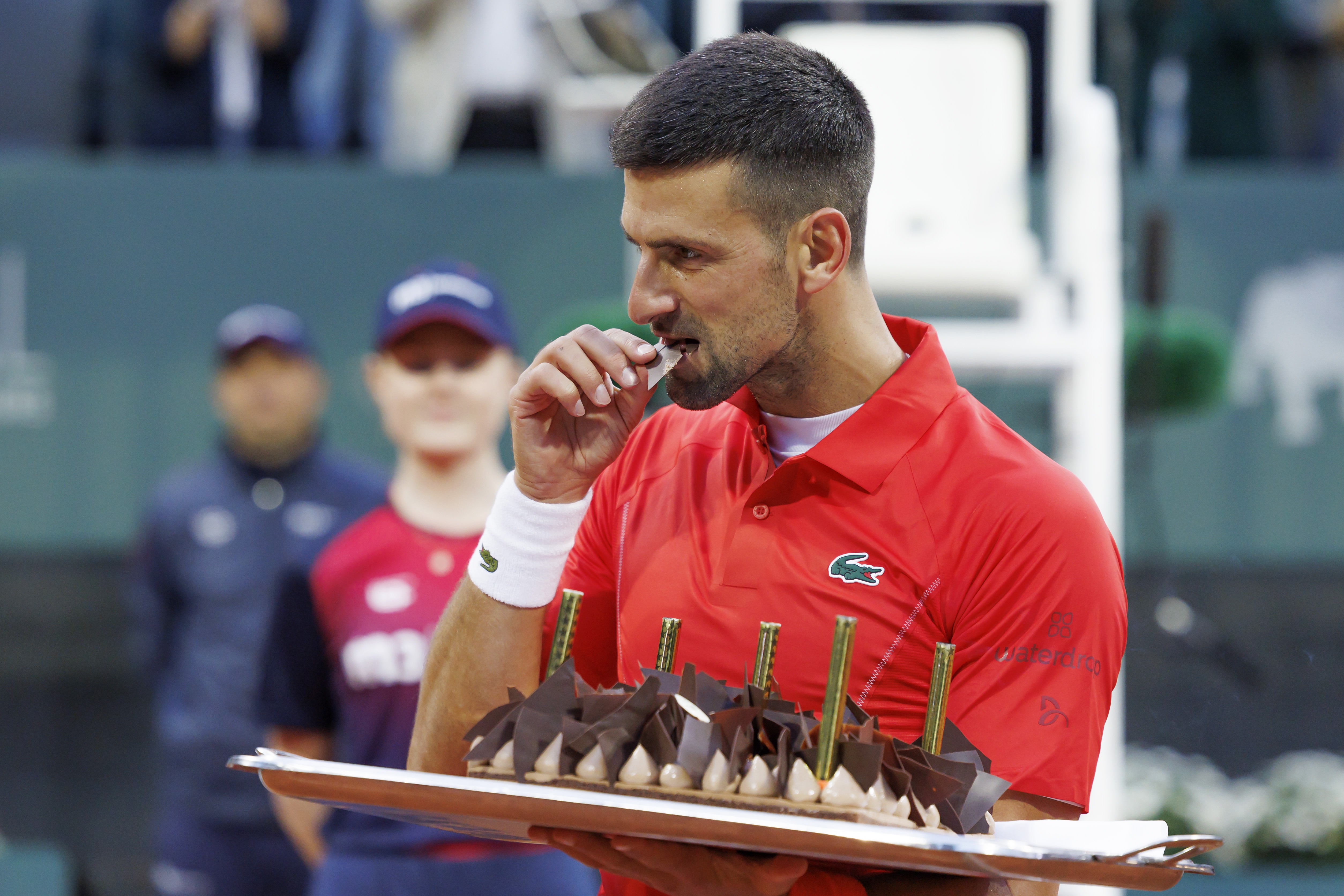 epa11361424 Serbia's Novak Djokovic tastes his birthday cake after he won the men's singles second round of the ATP 250 Geneva Open tournament in Geneva, Switzerland, 22 May 2024.  EPA-EFE/SALVATORE DI NOLFI