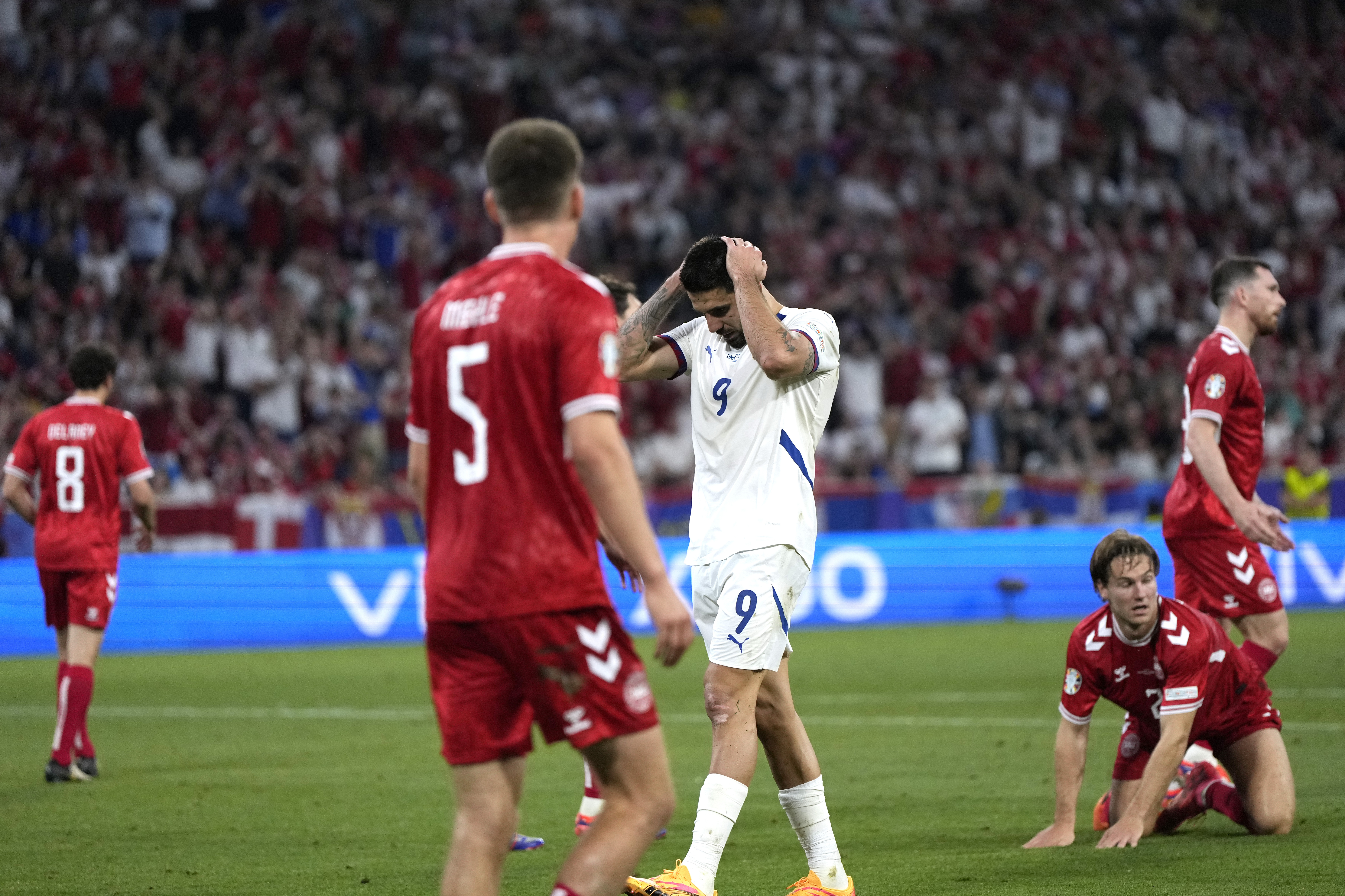 Serbia's Aleksandar Mitrovic, center right, reacts after a missed opportunity during a Group C match between Denmark and Serbia at the Euro 2024 soccer tournament in Munich, Germany, Tuesday, June 25, 2024. (AP Photo/Matthias Schrader)