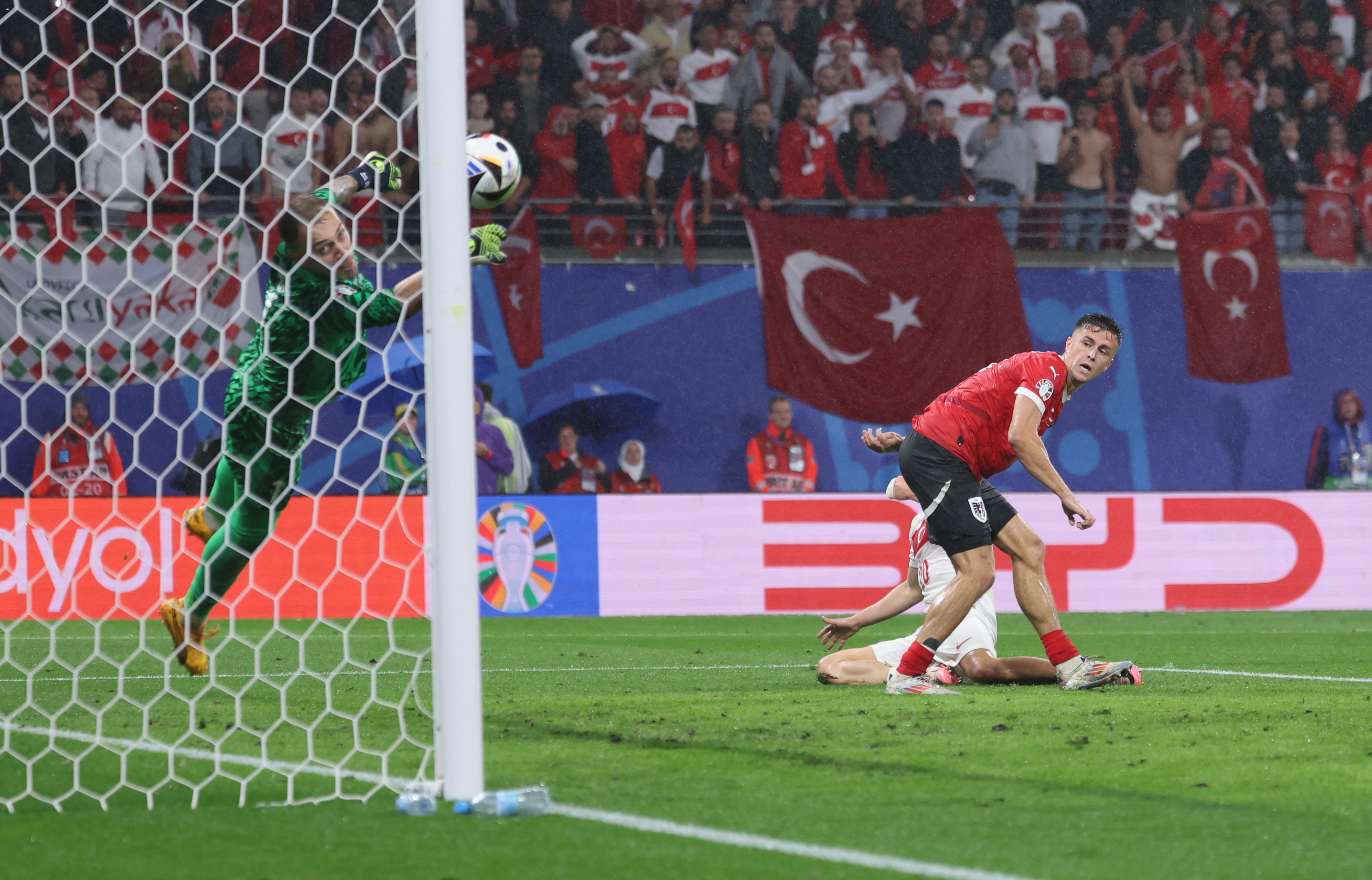 epa11453776 Turkey goalkeeper Mert Gunok (L) saves a shot from Christoph Baumgartner of Austria (R) during the UEFA EURO 2024 Round of 16 soccer match between Austria and Turkey, in Leipzig, Germany, 02 July 2024.  EPA-EFE/CHRISTOPHER NEUNDORF