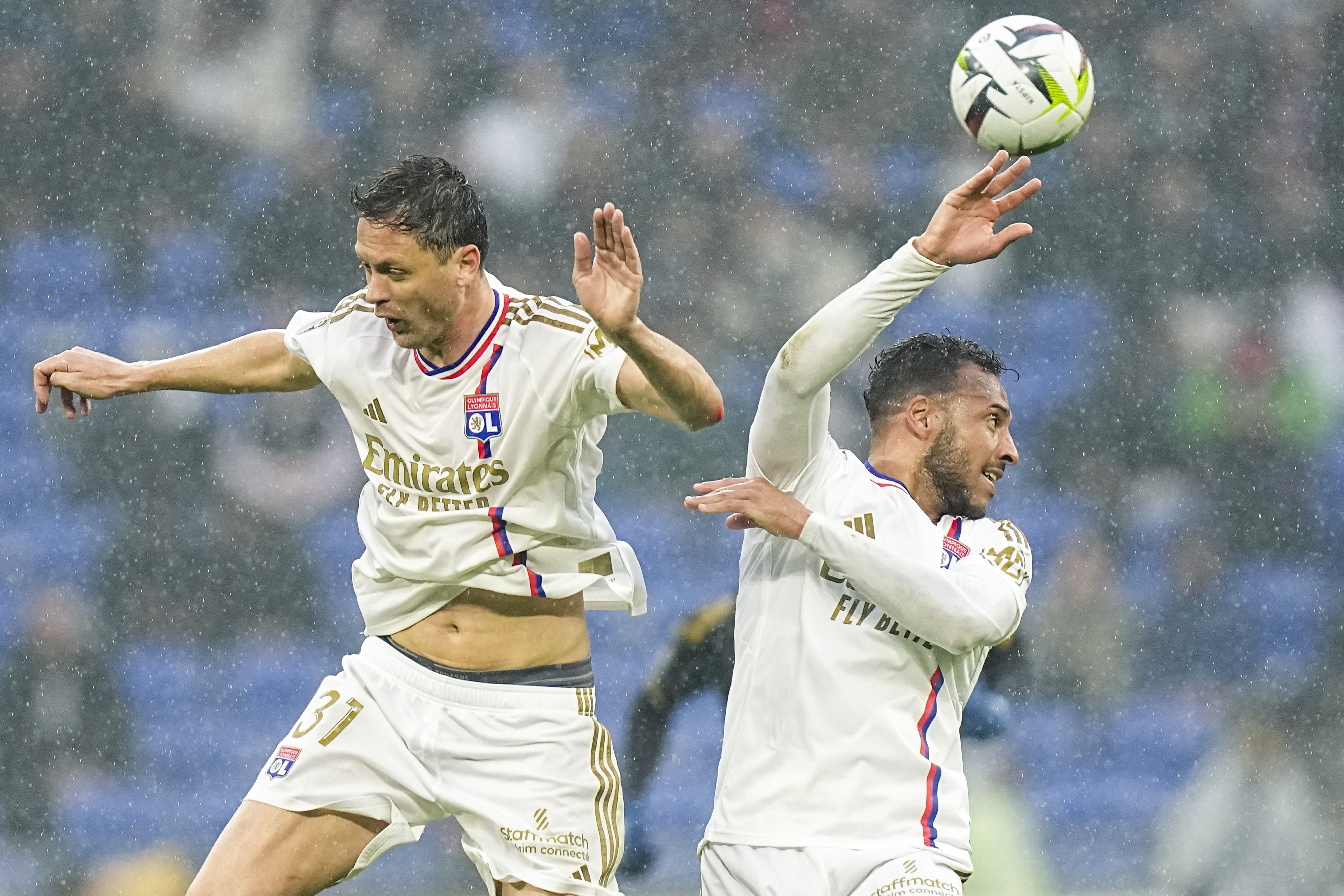 Lyon's Nemanja Matic, left, and Lyon's Corentin Tolisso jump to head the ball during a French League One soccer match between Lyon and Monaco at the Groupama stadium in Decines, outside Lyon, France, Sunday, April 28, 2024. (AP Photo/Laurent Cipriani)