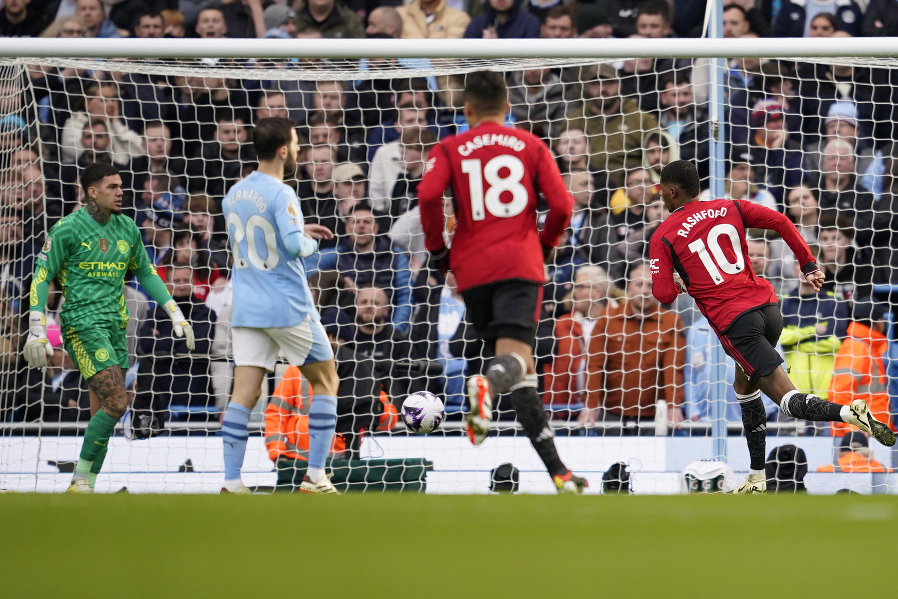 Manchester United's Marcus Rashford, rights,cores the opening goal during an English Premier League soccer match between Manchester City and Manchester United at the Etihad Stadium in Manchester, England, Sunday, March 3, 2024. (AP Photo/Dave Thompson)