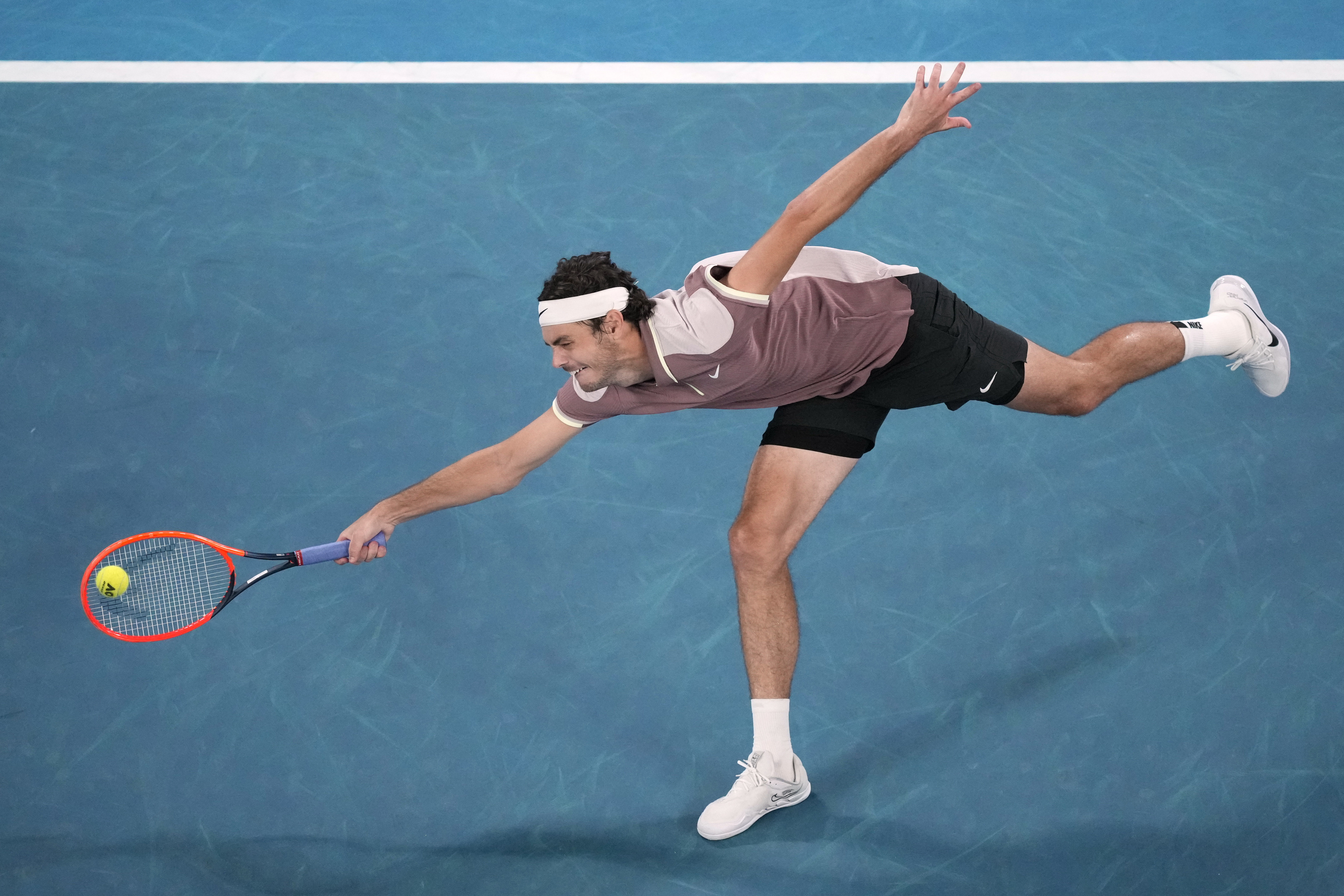 Taylor Fritz of the U.S. plays a forehand return to Stefanos Tsitsipas of Greece during their fourth round match at the Australian Open tennis championships at Melbourne Park, Melbourne, Australia, Sunday, Jan. 21, 2024. (AP Photo/Alessandra Tarantino)