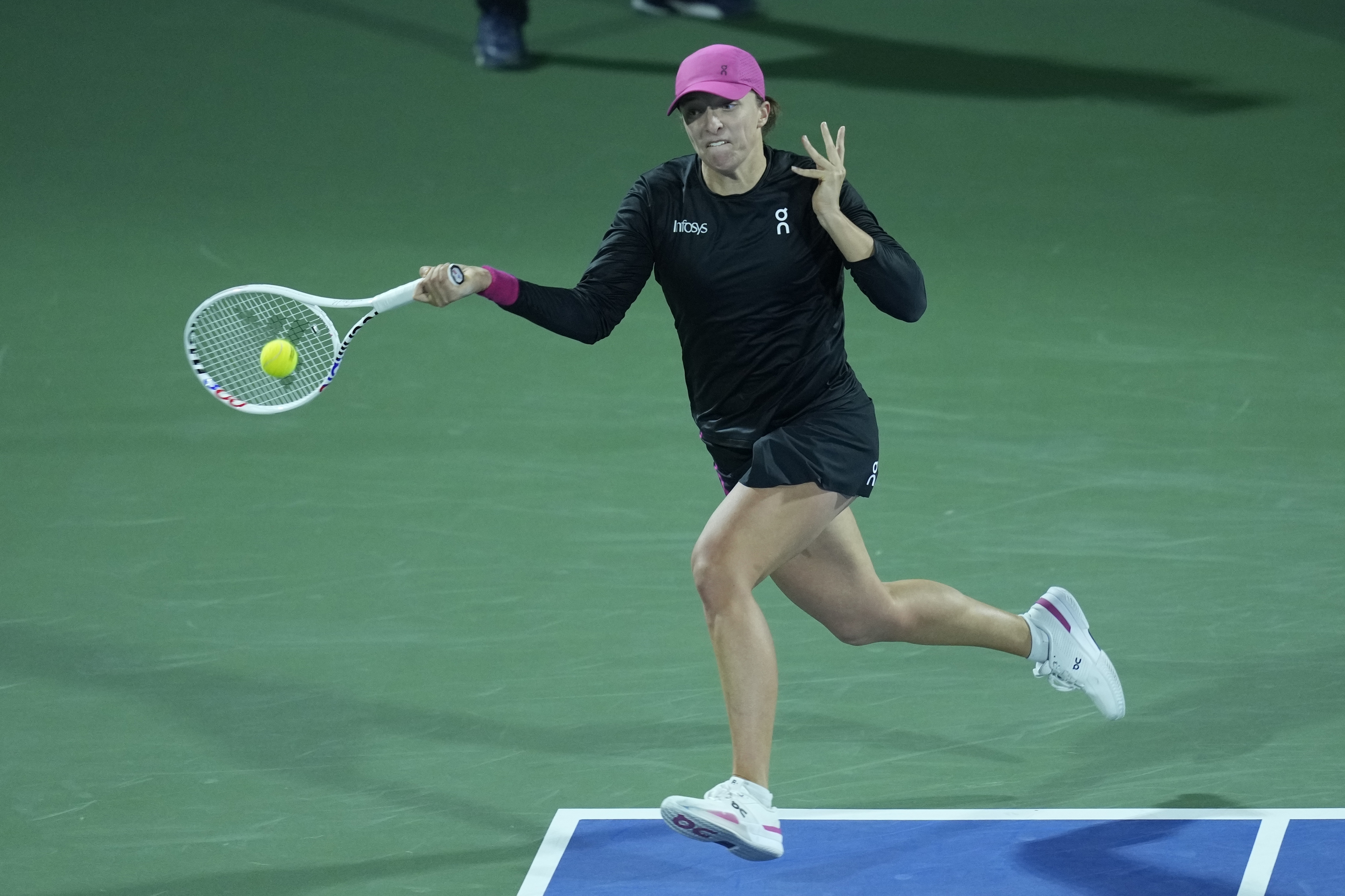 Iga Swiatek of Poland returns the ball to Qinwen Zheng of China during a quarter final match of the Dubai Duty Free Tennis Championships in Dubai, United Arab Emirates, Thursday, Feb. 22, 2024. (AP Photo/Kamran Jebreili)