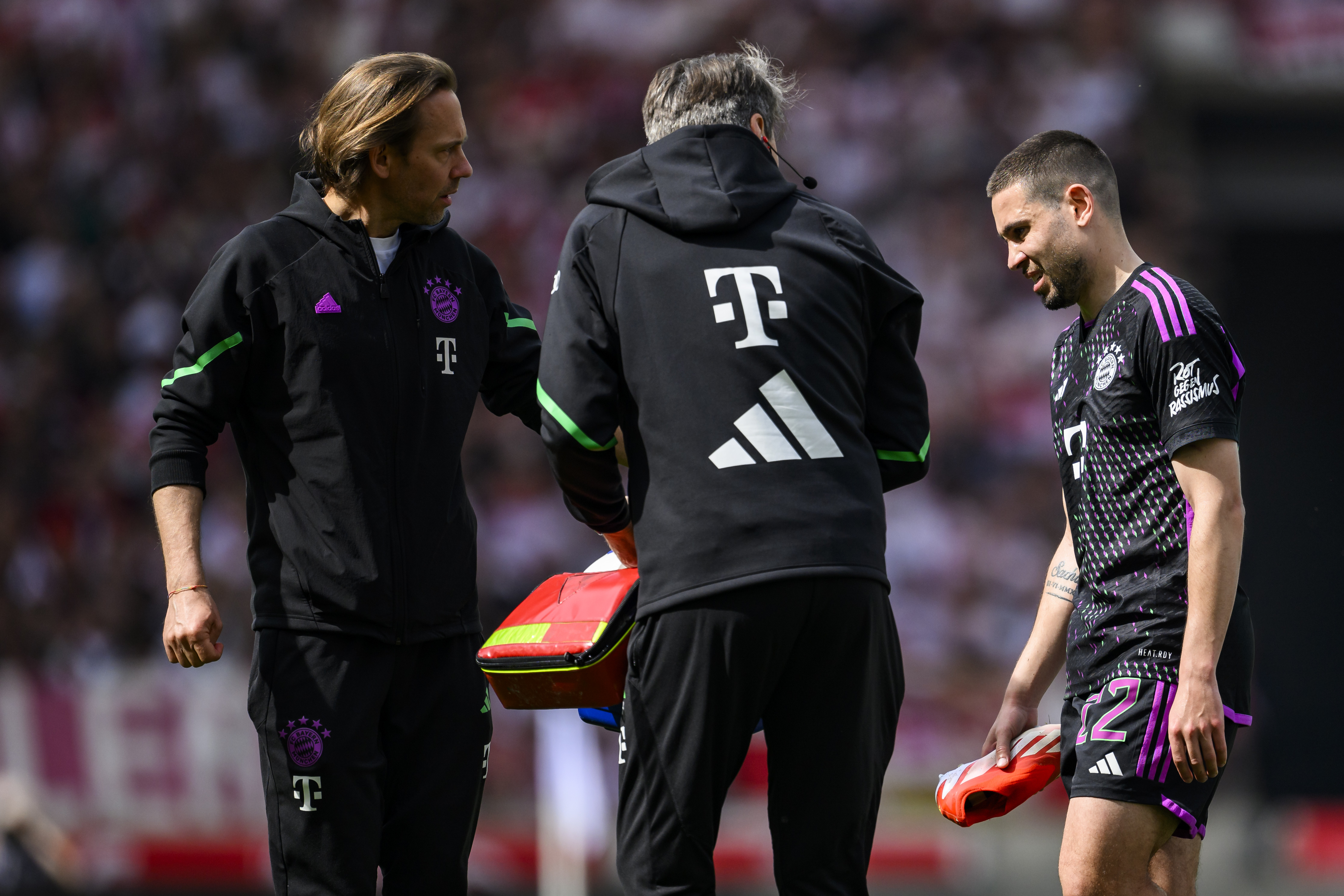 Munich's Raphael Guerreiro, right, leaves the pitch injured, during the German Bundesliga soccer match between Bayern Munich and VfB Stuttgart, in Stuttgart, Germany, Saturday, May 4, 2024. (Tom Weller/dpa via AP)