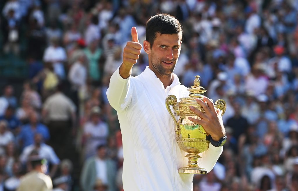 epa10064169 Novak Djokovic of Serbia holds the trophy and give thumb up after winning the men's final match against Nick Kyrgios of Australia at the Wimbledon Championships, in Wimbledon, Britain, 10 July 2022.  EPA-EFE/NEIL HALL   EDITORIAL USE ONLY