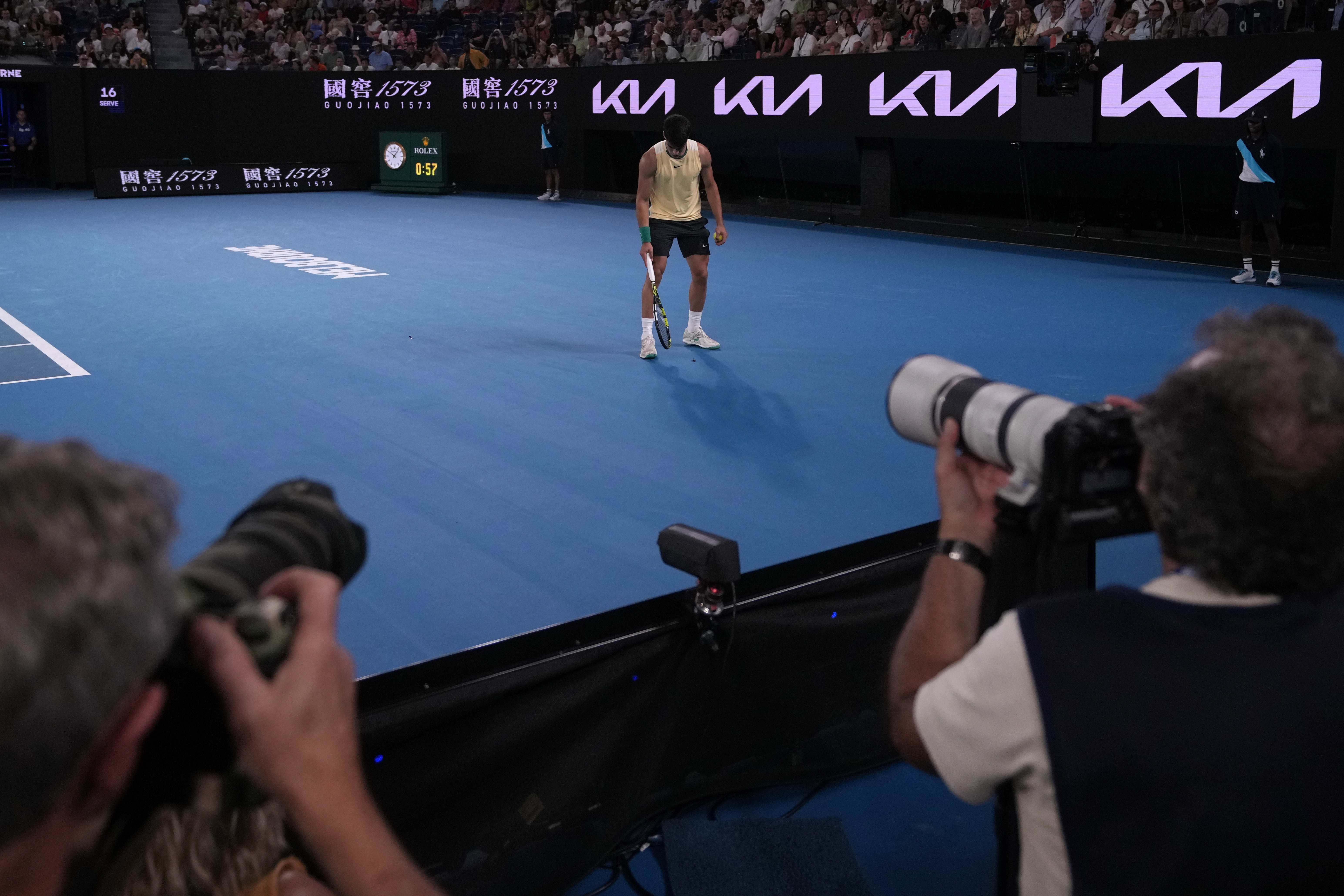 Carlos Alcaraz of Spain stops his first round match against Richard Gasquet of France to pickup an insect from the court at the Australian Open tennis championships at Melbourne Park, Melbourne, Australia, Tuesday, Jan. 16, 2024. (AP Photo/Andy Wong)