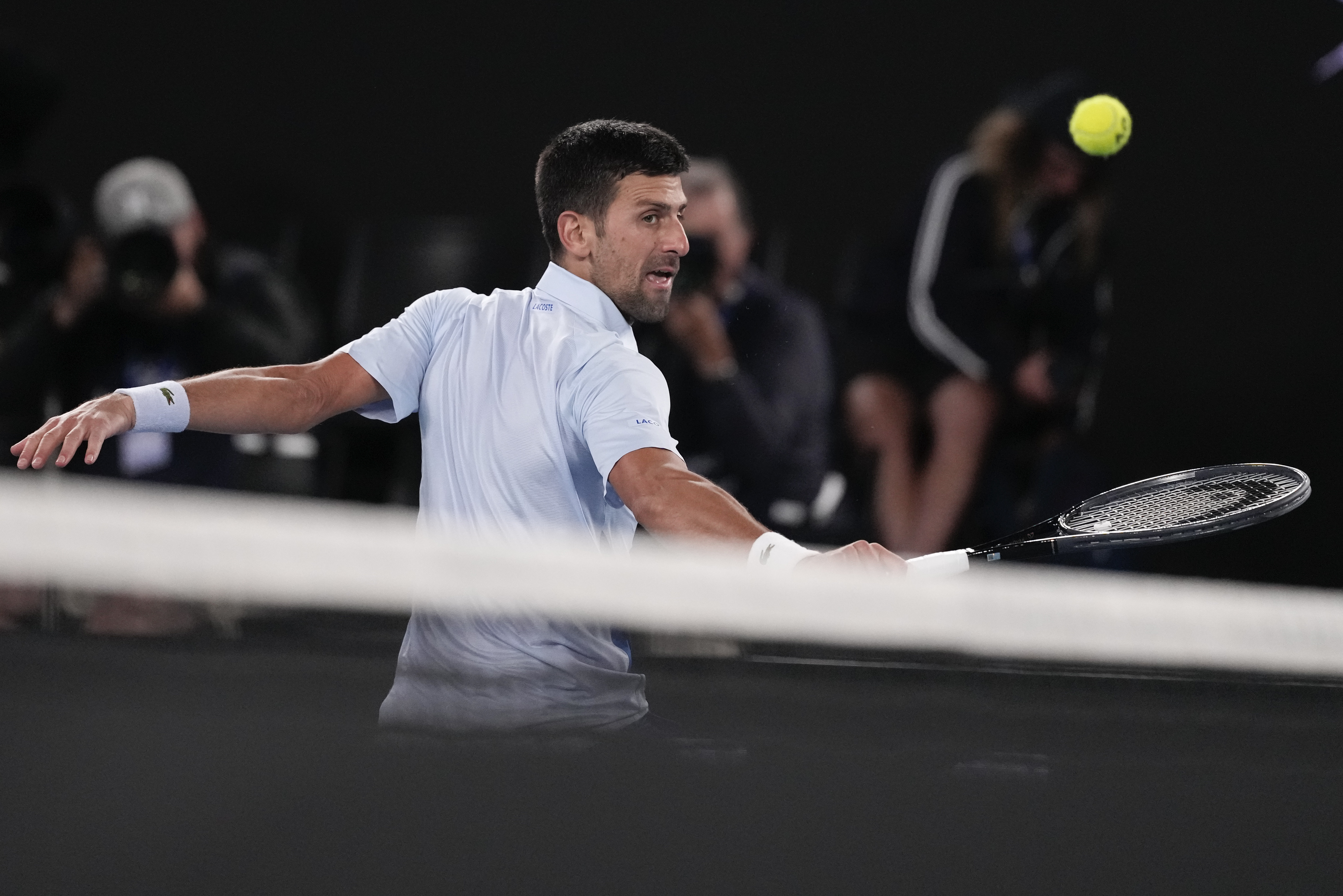 Serbia's Novak Djokovic plays a backhand return to Croatia's Dino Prizmic during their first round match at the Australian Open tennis championships at Melbourne Park, Melbourne, Australia, Sunday, Jan. 14, 2024. (AP Photo/Alessandra Tarantino)