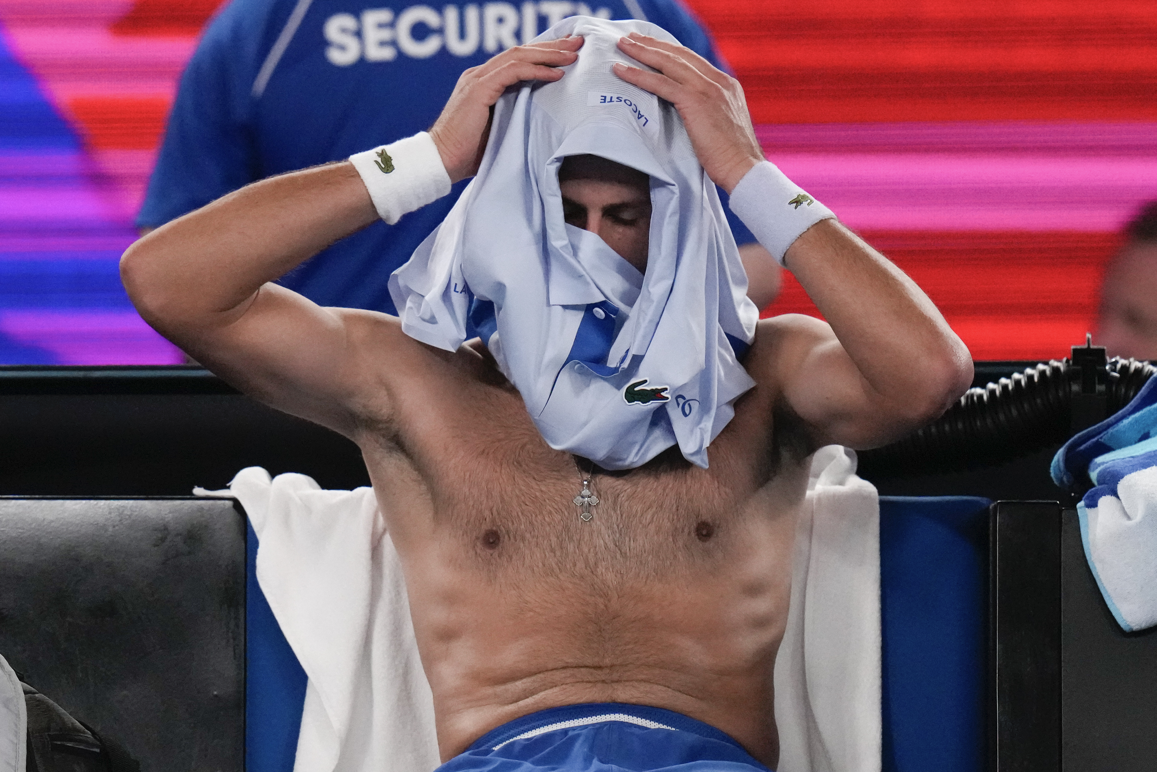 Serbia's Novak Djokovic changes his shirt during a break in his first round match against Croatia's Dino Prizmic at the Australian Open tennis championships at Melbourne Park, Melbourne, Australia, Sunday, Jan. 14, 2024. (AP Photo/Andy Wong)