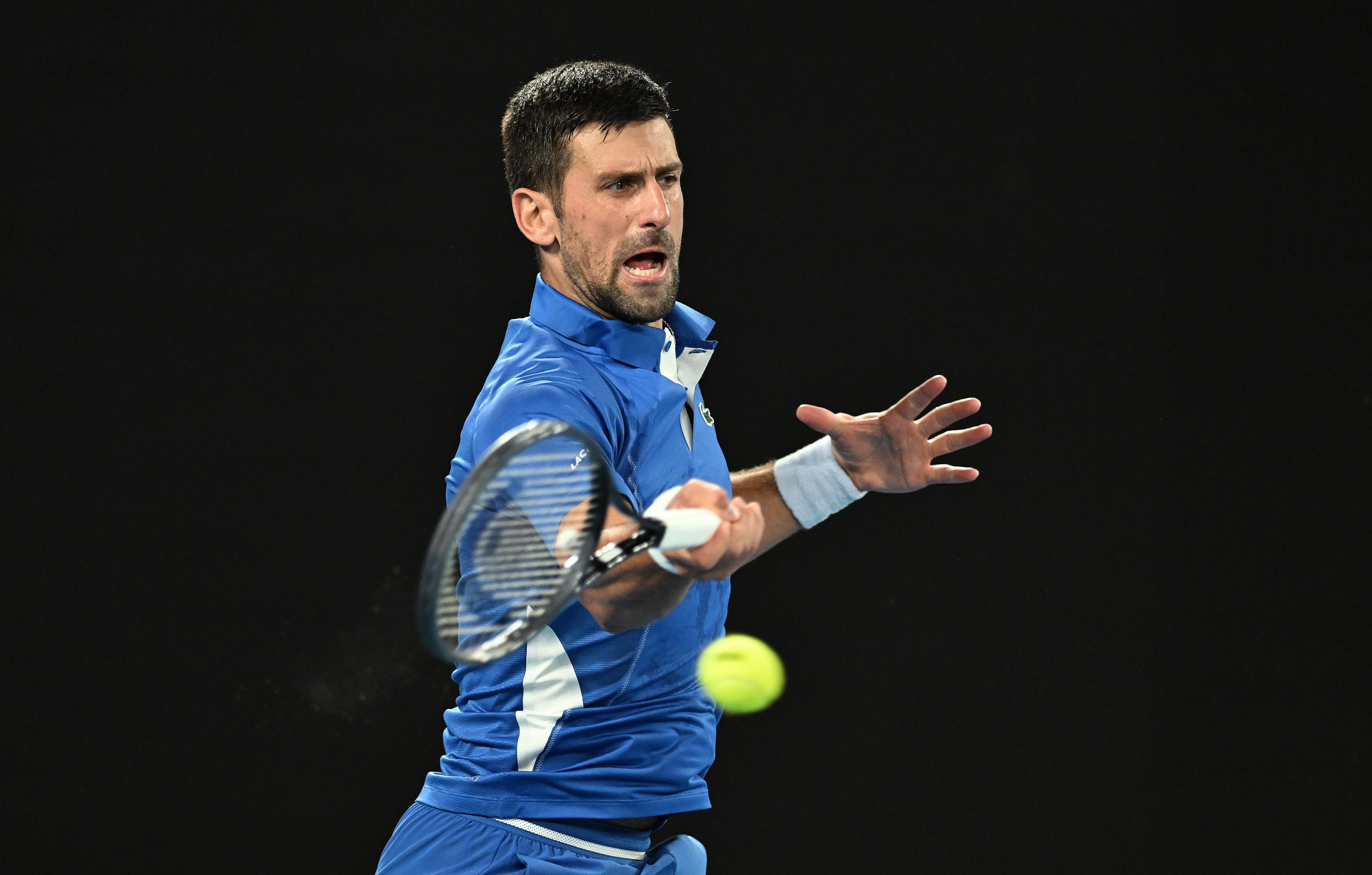 epa11075687 Novak Djokovic of Serbia returns during his first round match against Dino Prizmic of Croatia on Day 1 of the 2024 Australian Open at Melbourne Park in Melbourne, Australia, 14 January 2024.  EPA-EFE/LUKAS COCH AUSTRALIA AND NEW ZEALAND OUT