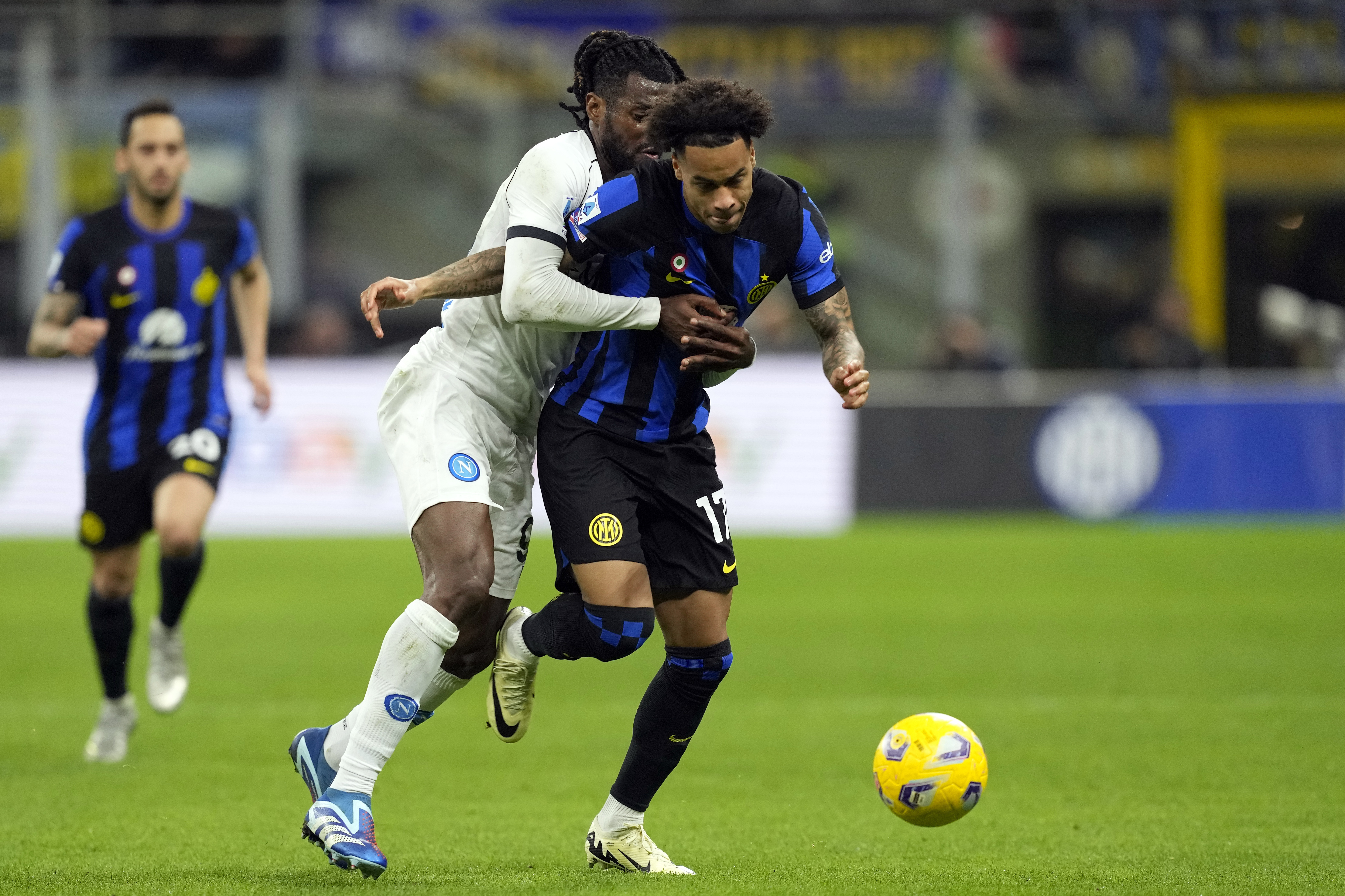 Napoli's Andre-Frank Zambo Anguissa fights for the ball with Inter Milan's Tajon Buchanan, right, during the Serie A soccer match between Inter Milan and Napoli at the San Siro Stadium, in Milan, Italy, Sunday, March 17, 2024. (AP Photo/Antonio Calanni)