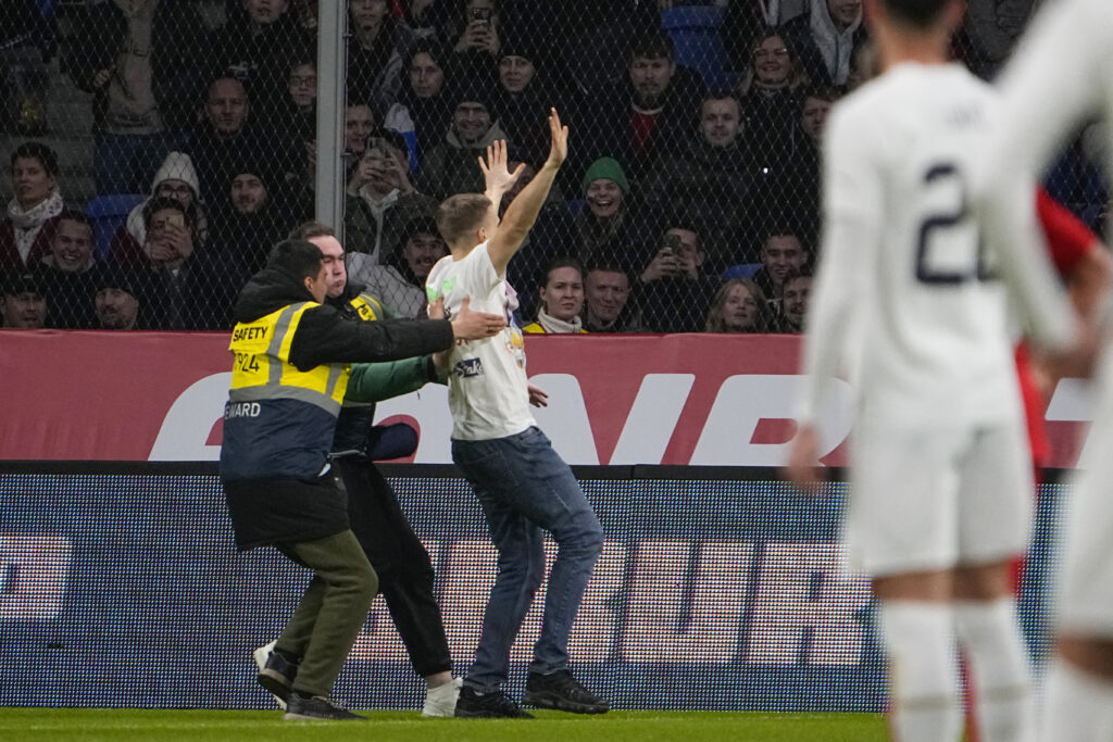 Stewards grab a pitch invader during an international friendly soccer match between Russia and Serbia at the Central Dynamo Stadium of Lev Yashin in Moscow, Russia, Thursday, March 21, 2024. (AP Photo/Alexander Zemlianichenko)