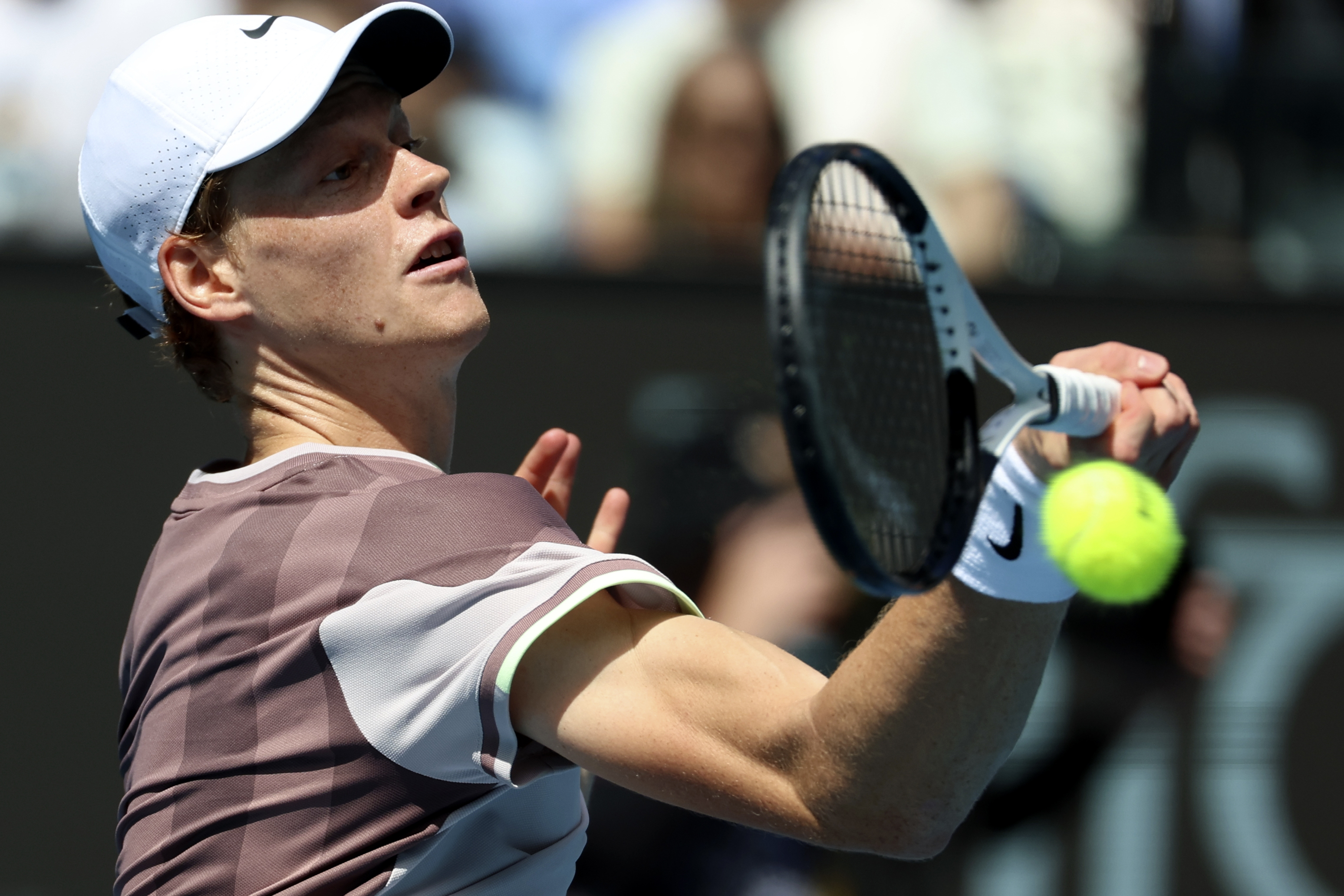Jannik Sinner of Italy plays a forehand return to Novak Djokovic of Serbia during their semifinal at the Australian Open tennis championships at Melbourne Park, Melbourne, Australia, Friday, Jan. 26, 2024. (AP Photo/Asanka Brendon Ratnayake)