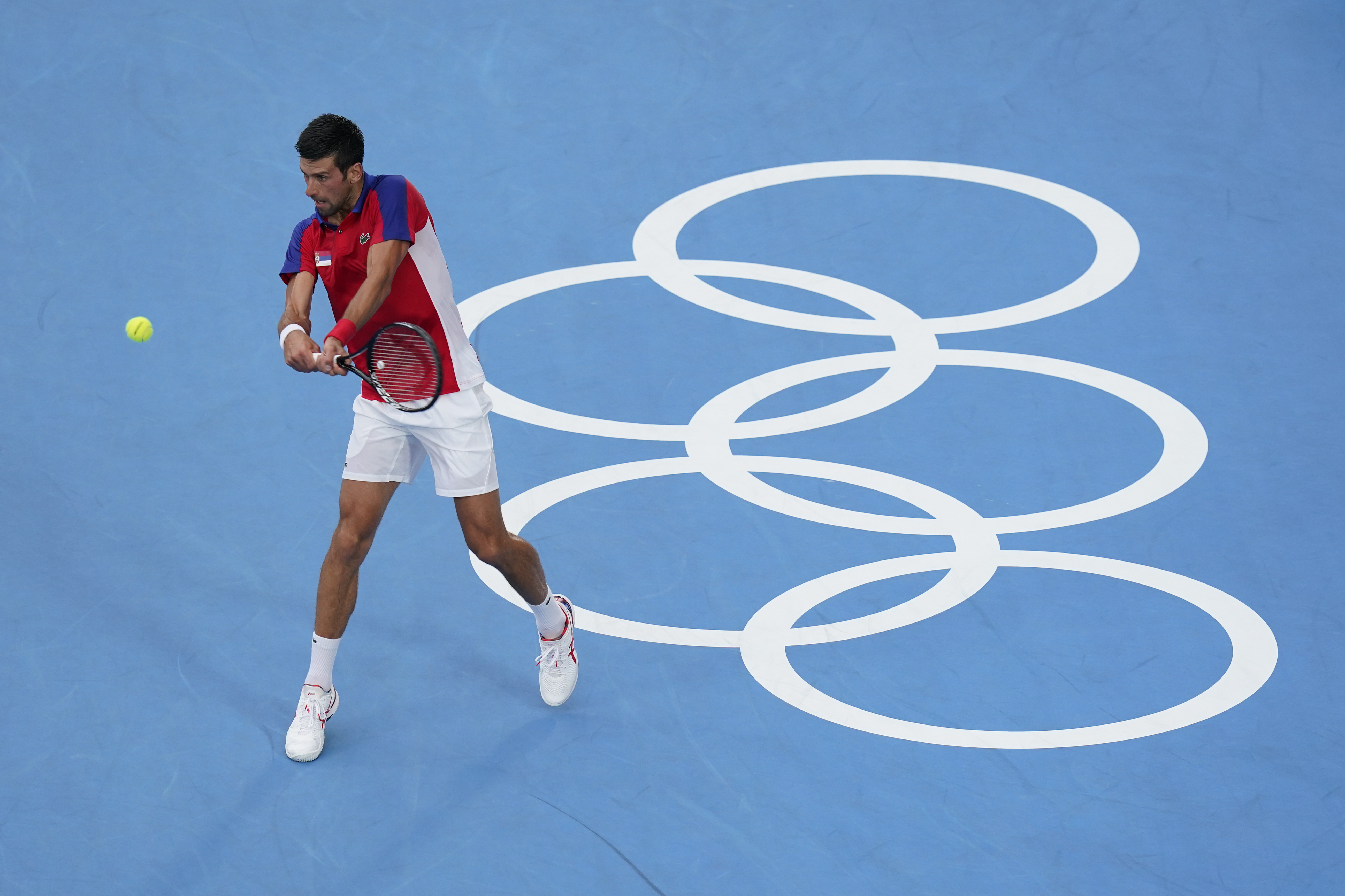 Novak Djokovic, of Serbia, returns to Alexander Zverev, of Germany, during the semifinal round of the men's tennis competition at the 2020 Summer Olympics, Friday, July 30, 2021, in Tokyo, Japan. (AP Photo/Patrick Semansky)
