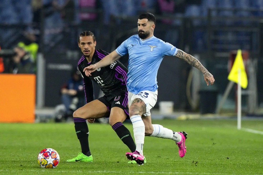 epa11153490 Bayern's Leroy Sane (L) and Lazio's Elseid Hysaj (R) in action during the UEFA Champions League Round of 16, 1st leg soccer match SS Lazio vs FC Bayern Munich in Rome, Italy, 14 February 2024.  EPA-EFE/ANGELO CARCONI