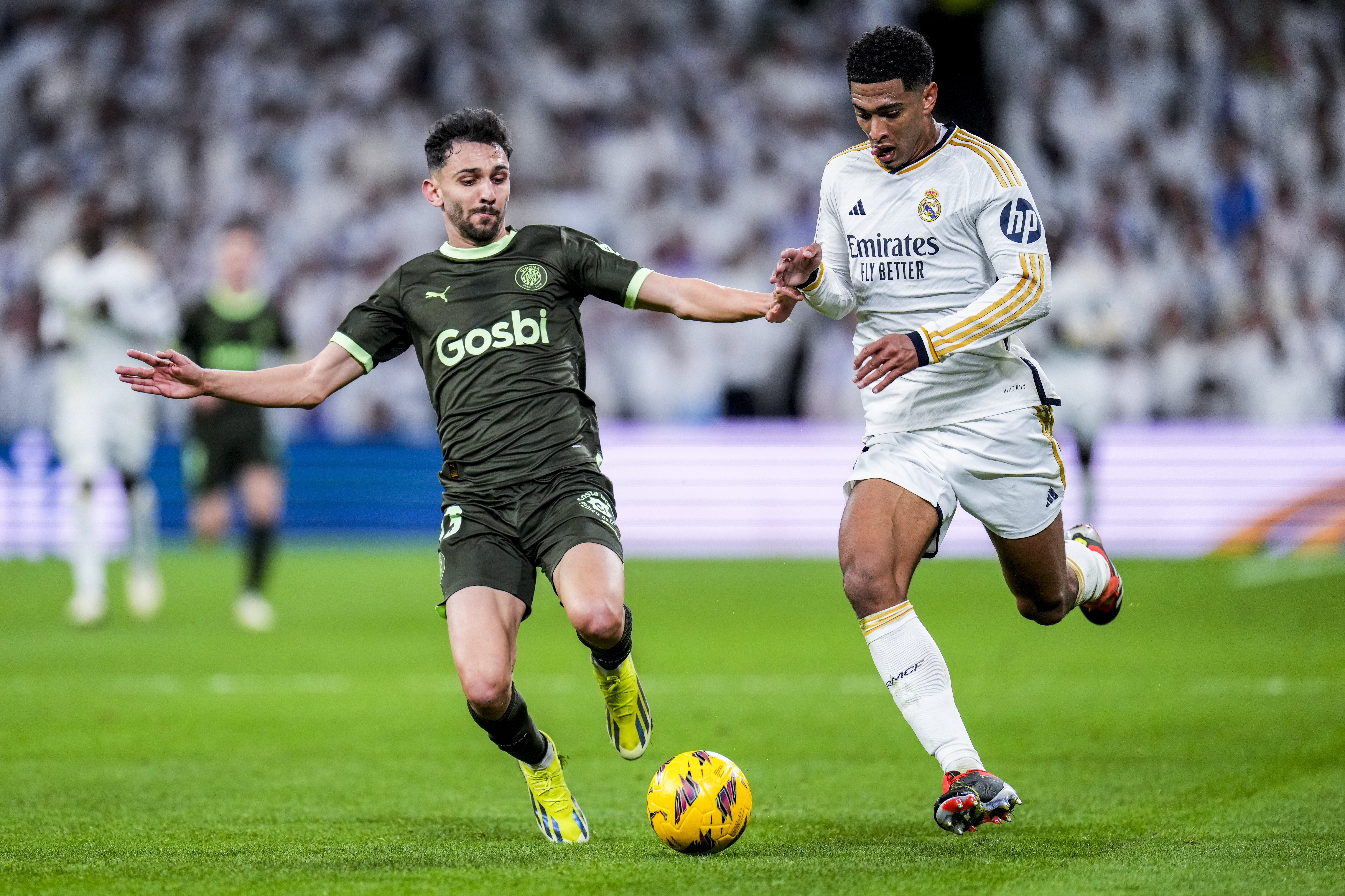 Real Madrid's Jude Bellingham, right, duels for the ball with Girona's Ivan Martin during a Spanish La Liga soccer match between Real Madrid and Girona at the Santiago Bernabeu stadium in Madrid, Spain, Saturday, Feb. 10, 2024. (AP Photo/Manu Fernandez)