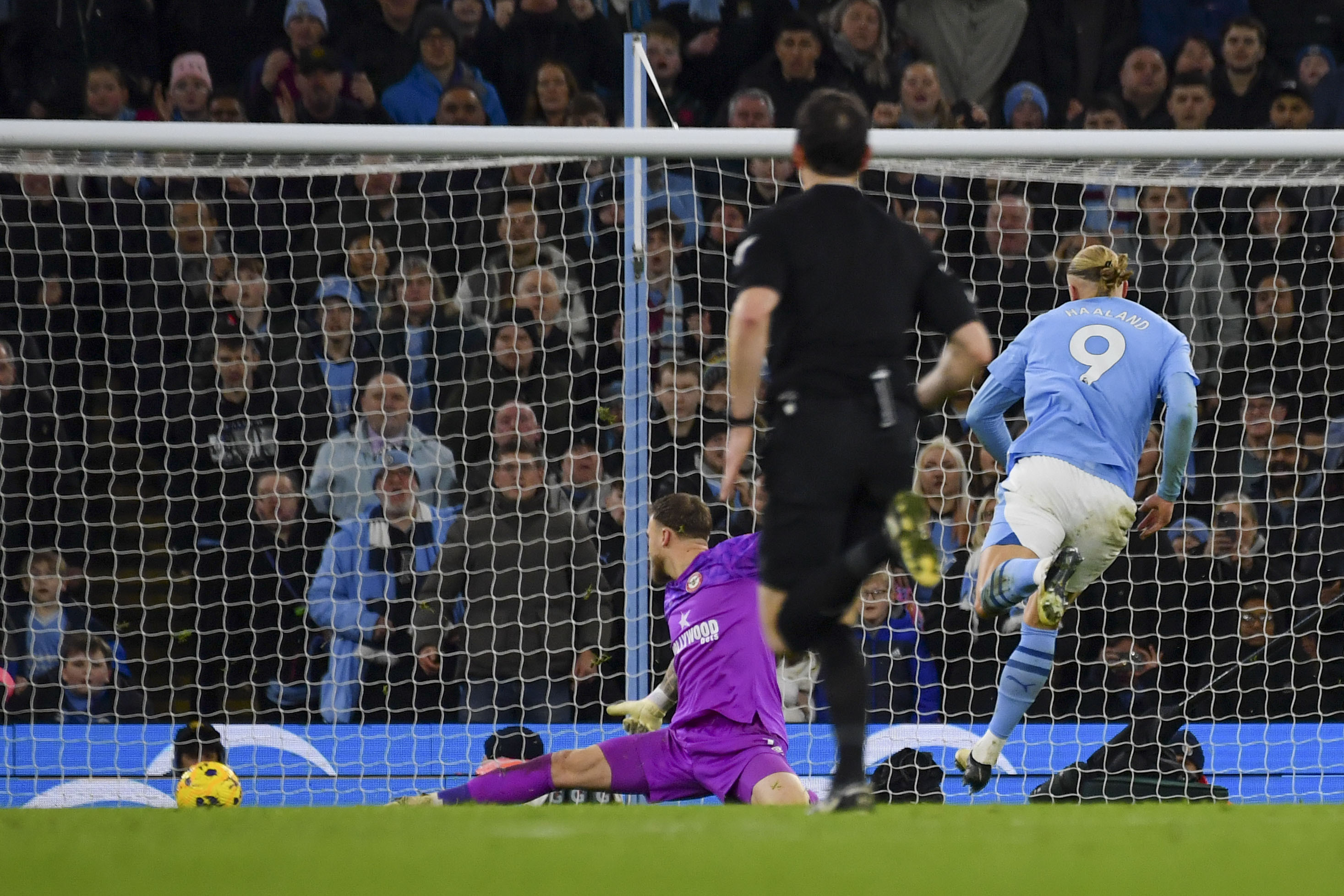 Manchester City's Erling Haaland, right, scores his side's opening goal during the English Premier League soccer match between Manchester City and Brentford at the Etihad stadium in Manchester, England, Tuesday, Feb. 20, 2024. (AP Photo/Rui Vieira)