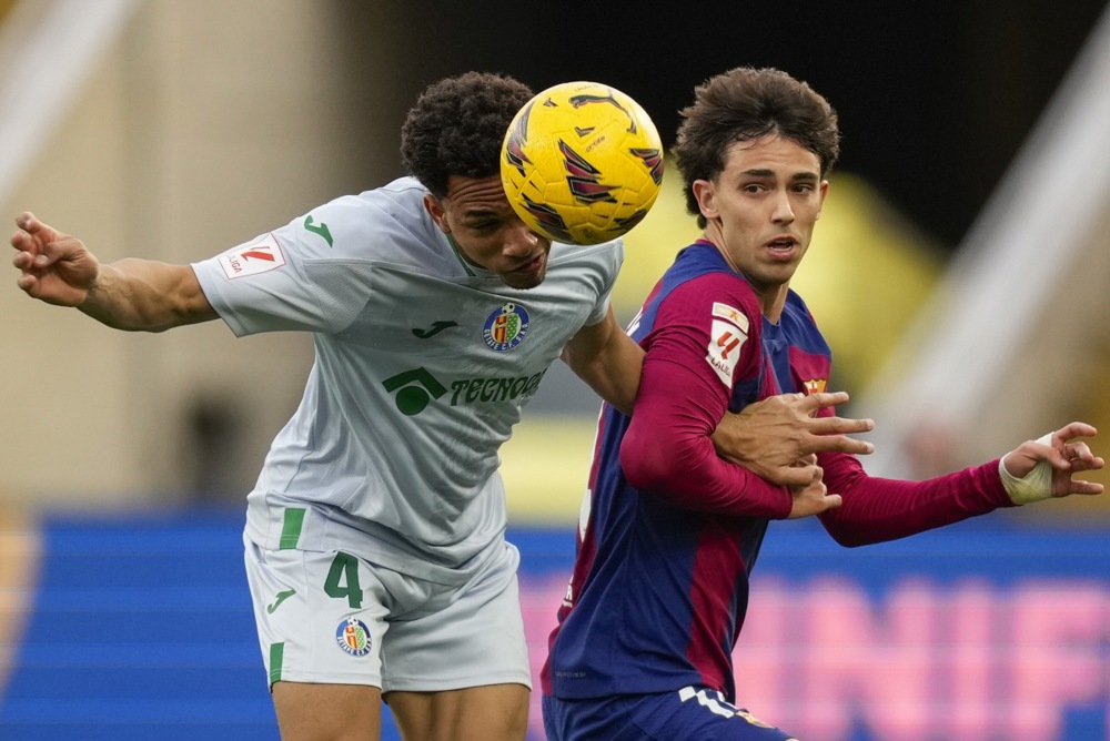 epa11178073 FC Barcelona's striker Joao Felix (R) in action against Getafe's defender Gaston Alvarez (L) during the Spanish LaLiga soccer match between FC Barcelona and Getafe CF, in Barcelona, Spain, 24 February 2024.  EPA-EFE/Enric Fontcuberta