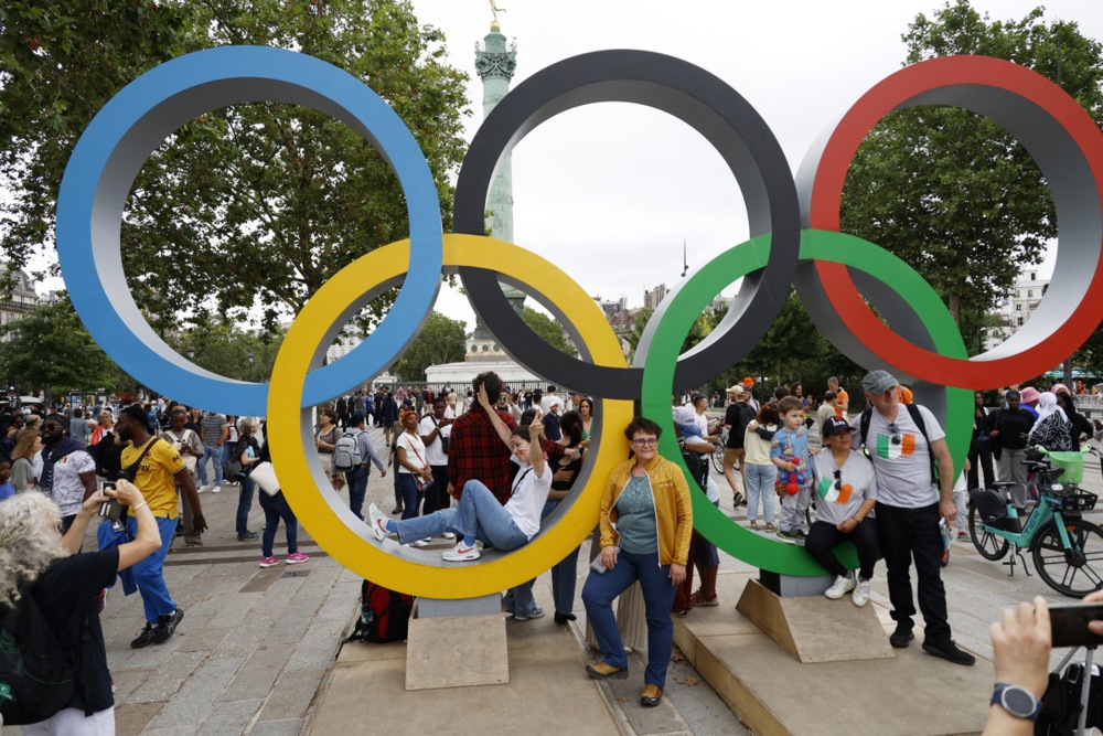 epa11497212 Spectators pose for photos with the Olympic rings ahead of the Opening Ceremony of the Paris 2024 Olympic Games, in Paris, France, 26 July 2024.  EPA-EFE/FRANCK ROBICHON