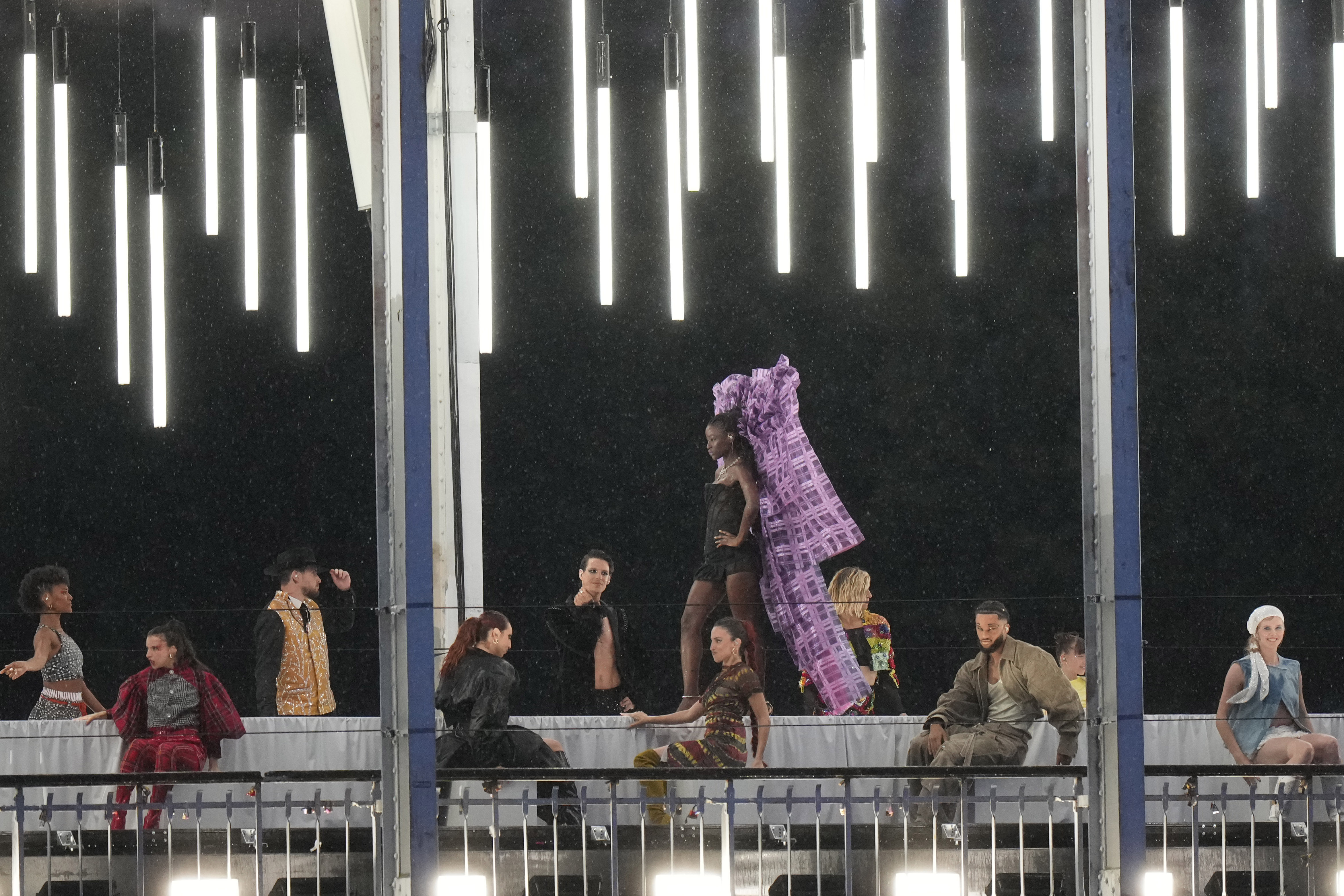 Models walk during a fashion show over the Seine River bridge in Paris, France, at the opening ceremony of the 2024 Summer Olympics, Friday, July 26, 2024. (AP Photo/Andrew Medichini)