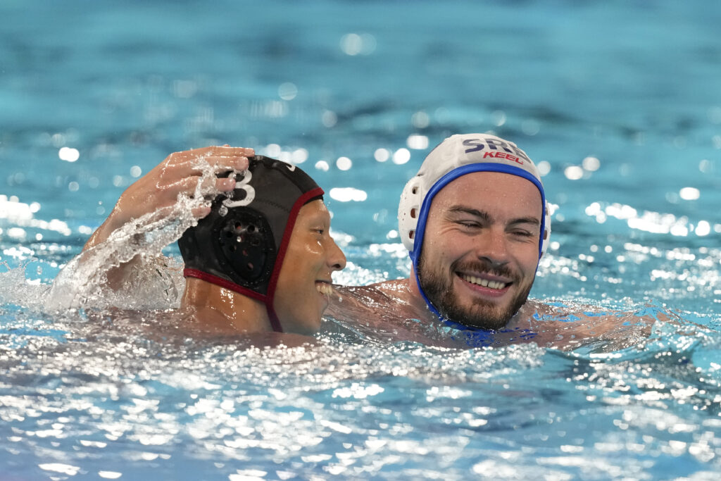 Serbia's Radomir Drasovic, right, talks with Japan's Taiyo Watanabe during the men's Water Polo Group B preliminary match between Serbia and Japan at the 2024 Summer Olympics, Sunday, July 28, 2024, in Saint-Denis, France. (AP Photo/Luca Bruno)