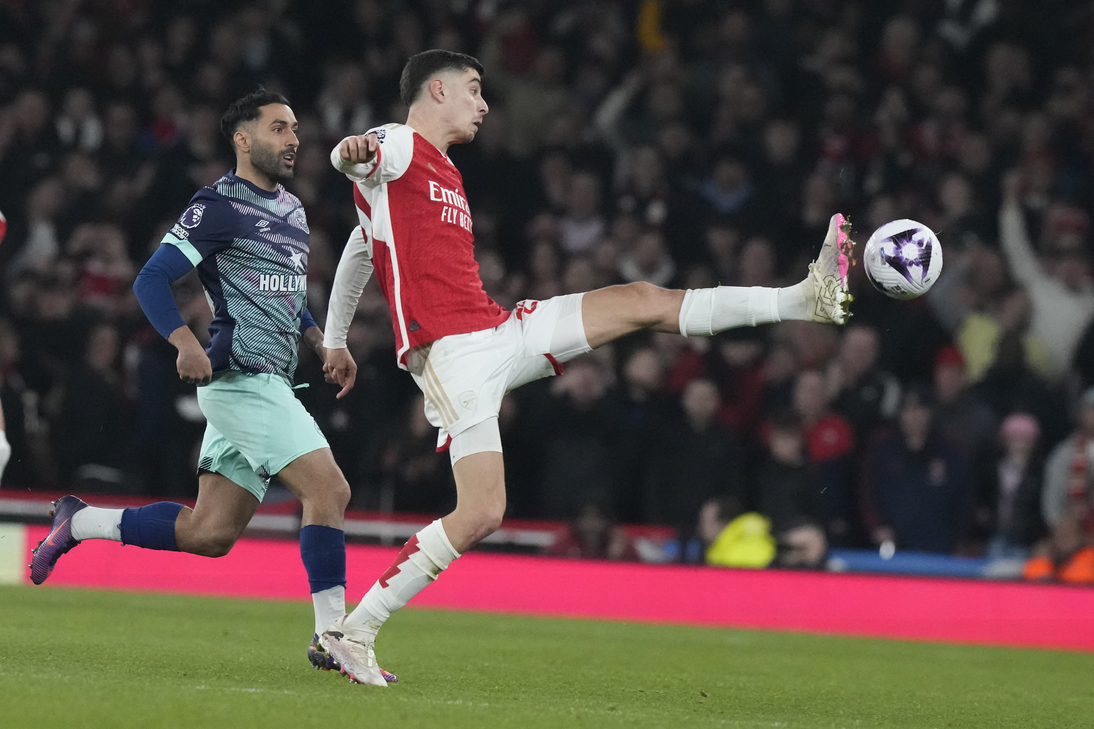 Arsenal's Kai Havertz, right, challenges for the ball during the English Premier League soccer match between Arsenal and Brentford at the Emirates Stadium in London, England, Saturday, March 9, 2024. (AP Photo/Frank Augstein)