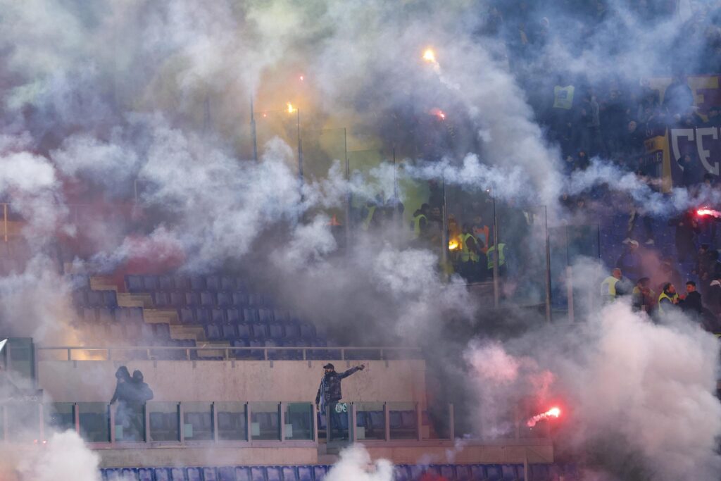 epa11067786 Smoke from smoke bombs billows between supporters before the Coppa Italia quarter final soccer match between SS Lazio and AS Roma, in Rome, Italy, 10 January 2024.  EPA-EFE/FABIO FRUSTACI