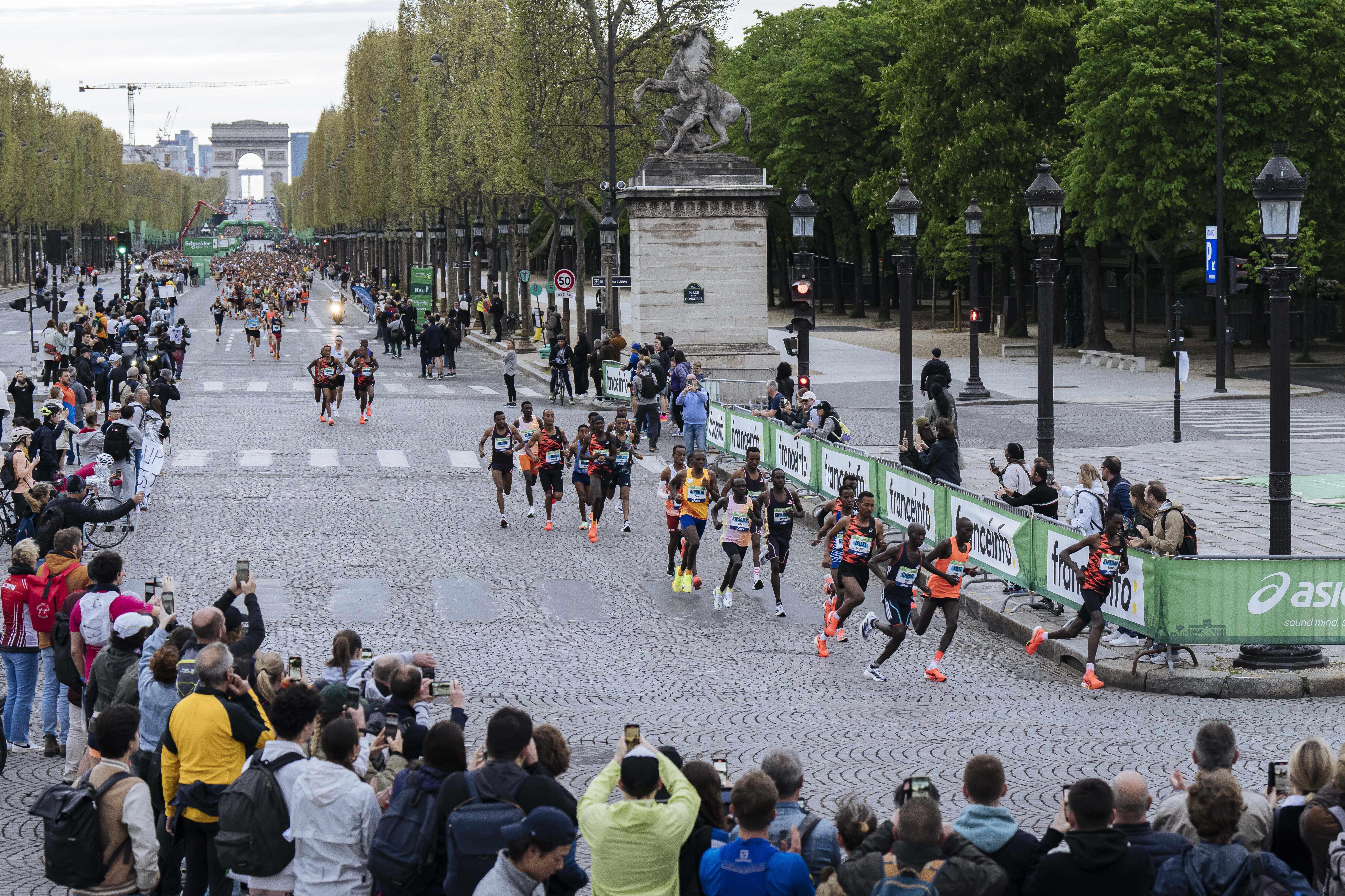 Elite athletes run at the start of the Paris marathon on the Champs-Elysees avenue, with the Arc de Triomphe in the background, in Paris, Sunday, April 7, 2024. (AP Photo/Lewis Joly)