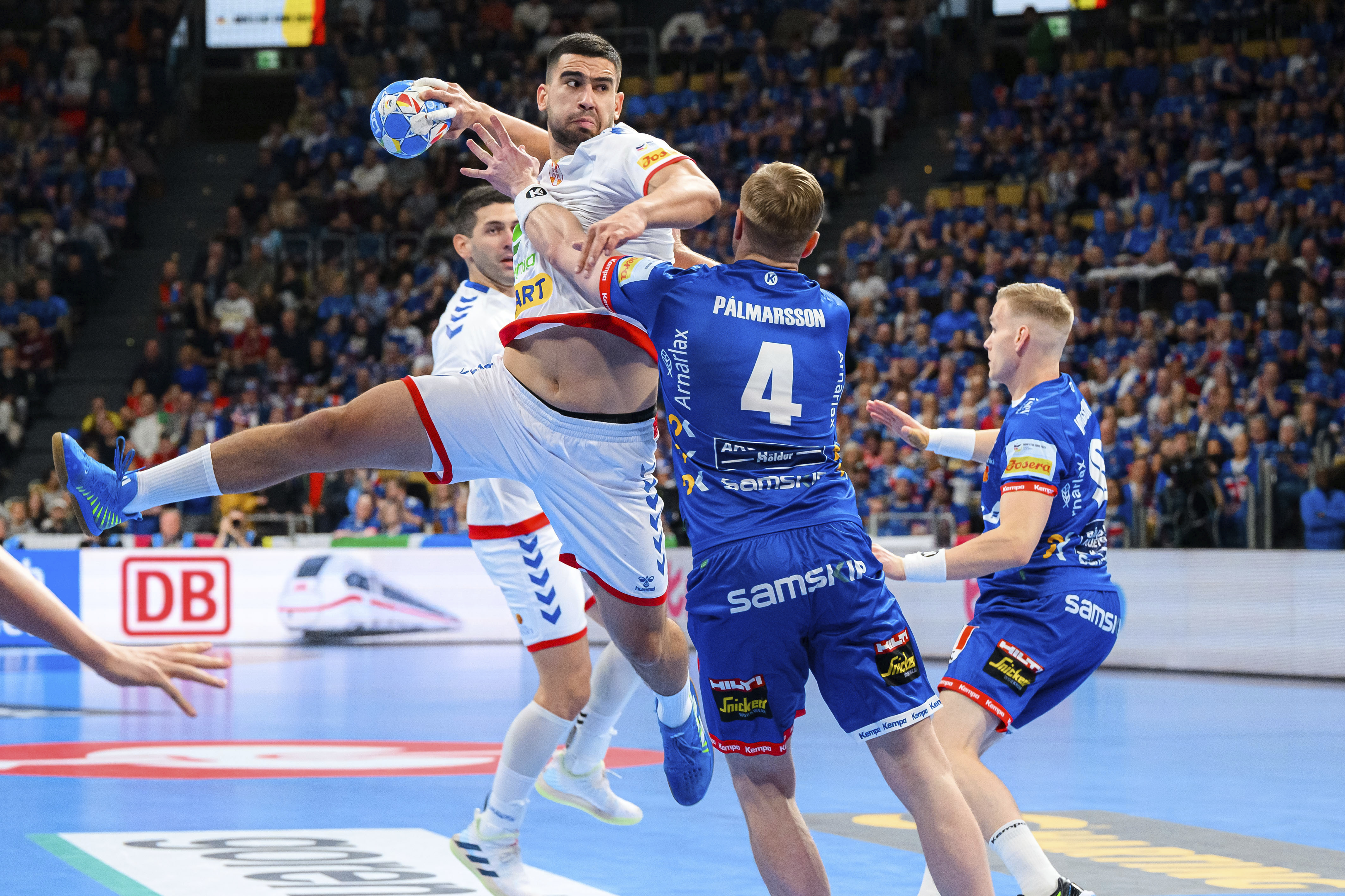 Serbia's Milos Kos, left, is challenged by Iceland's Aron Palmarsson during the Men's European Handball Championship match between Iceland and Serbia in Munich, Germany, Friday, Jan. 12, 2024. (Marco Wolf/dpa via AP)