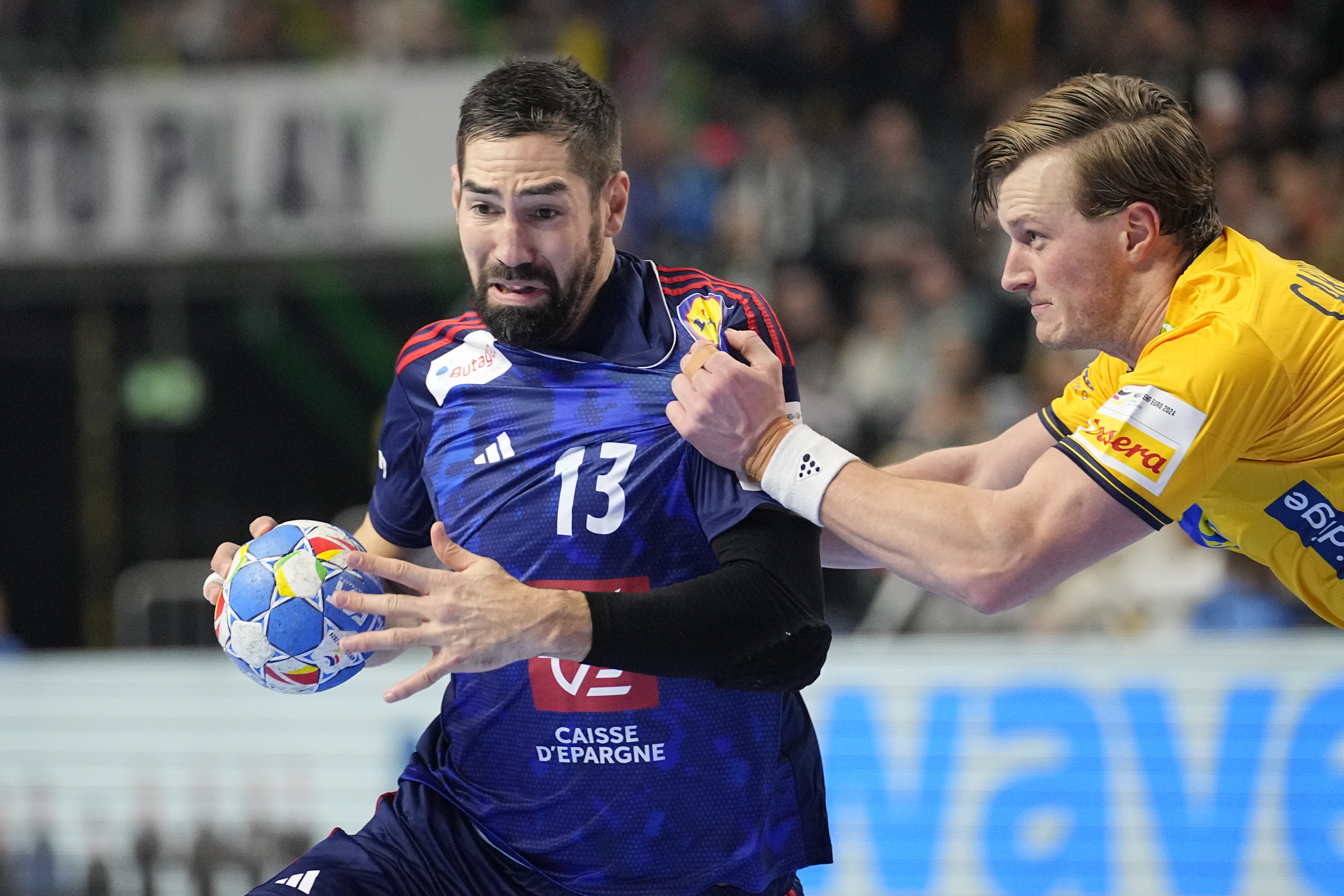 France's Nikola Karabatic is challenged by Sweden's Jonathan Carlsbogard during the Handball European Championship semifinal match between France and Sweden in Cologne, Germany, Friday, Jan. 26, 2024. (AP Photo/Martin Meissner)