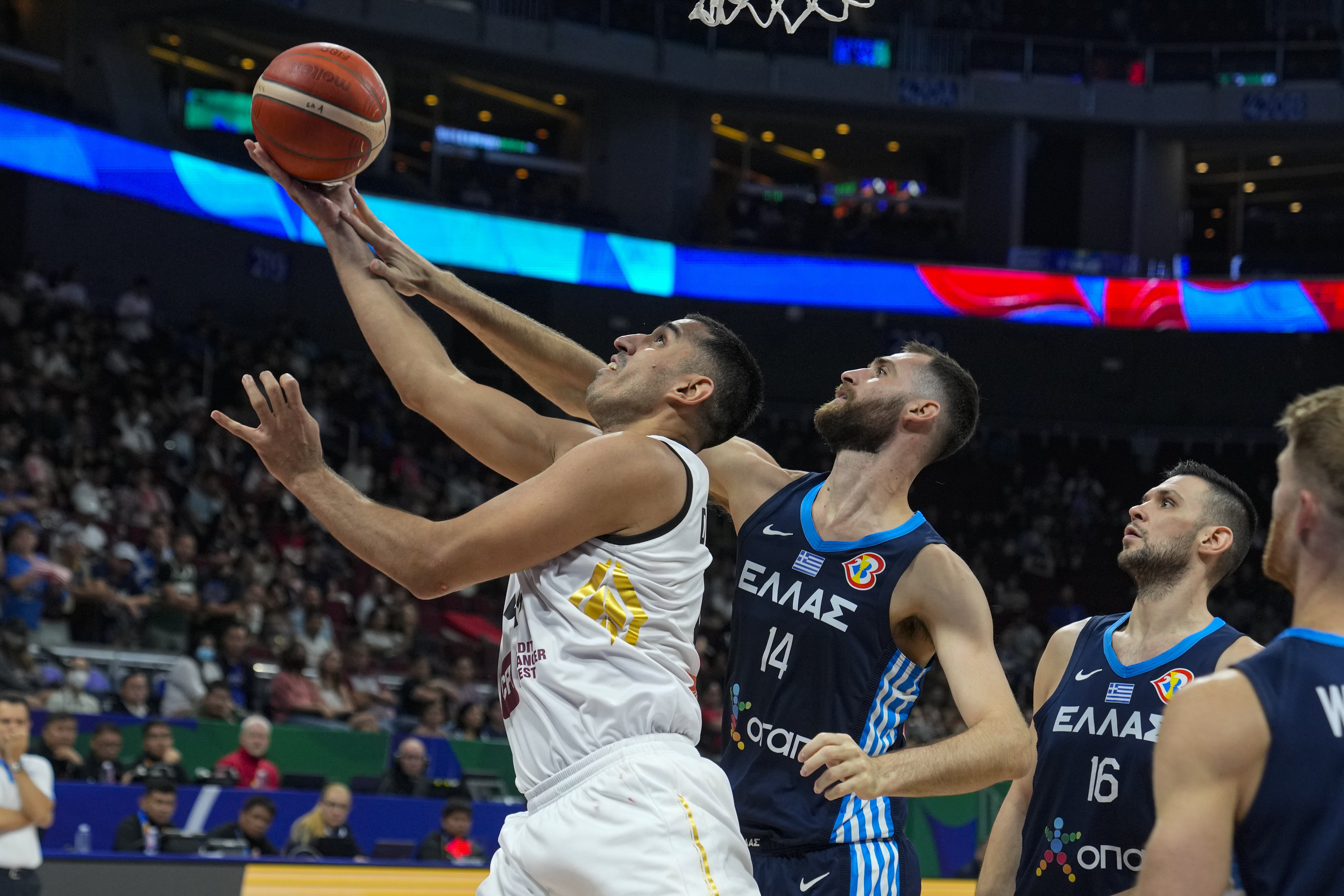 Jordan center Ahmad Dwairi (44) shoots under Greece center Georgios Papagiannis (14) during the second half of a Basketball World Cup group C match in Manila, Saturday, Aug. 26, 2023. (AP Photo/Michael Conroy)