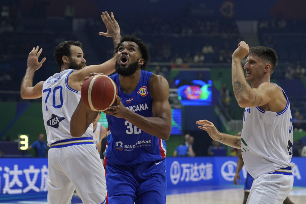 Dominican Republic forward Karl-Anthony Towns (32) against Italy forward Luigi Datome (70) during their Basketball World Cup group A match at the Araneta Coliseum in Manila, Philippines Sunday, Aug. 27, 2023. (AP Photo/Aaron Favila)
