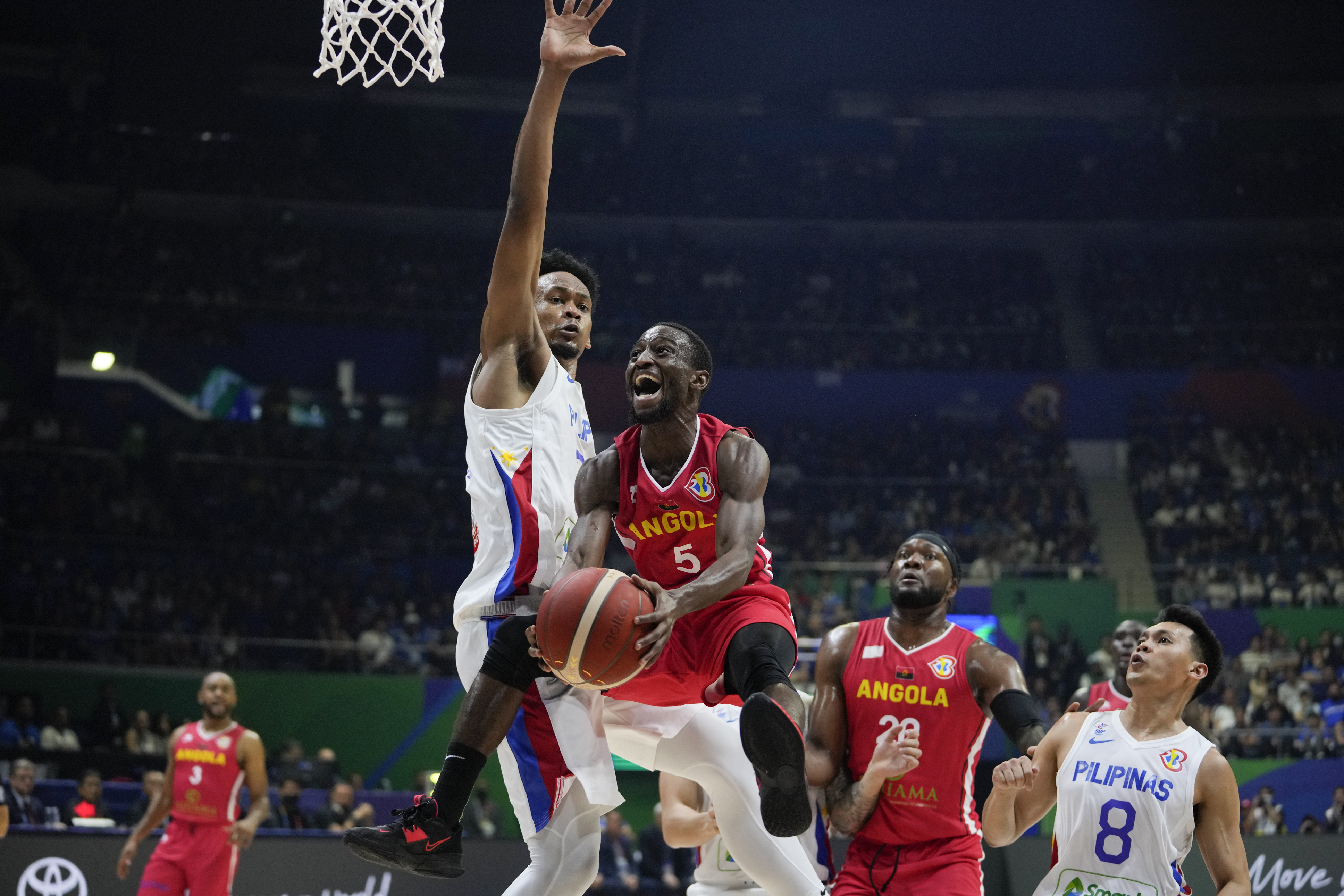 Angola guard Childe Dundao (5) shoots the ball against Philippines center Ariel John Edu (34) during their Basketball World Cup group A match at the Araneta Coliseum in Manila, Philippines Sunday, Aug. 27, 2023. (AP Photo/Aaron Favila)