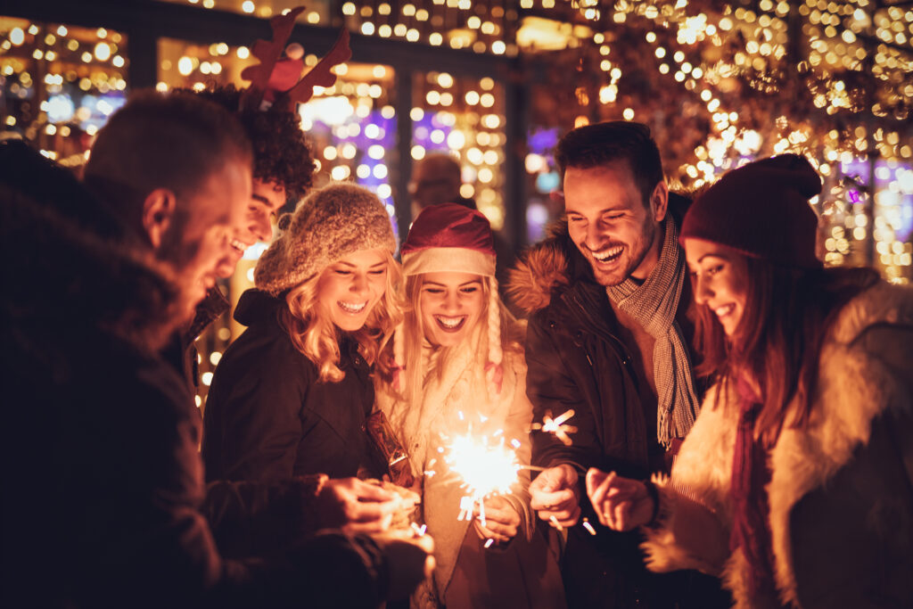 Three couple with sparklers enjoying Christmas outdoor party in the city street at night and with a lot of lights on background.
Flixbus PR