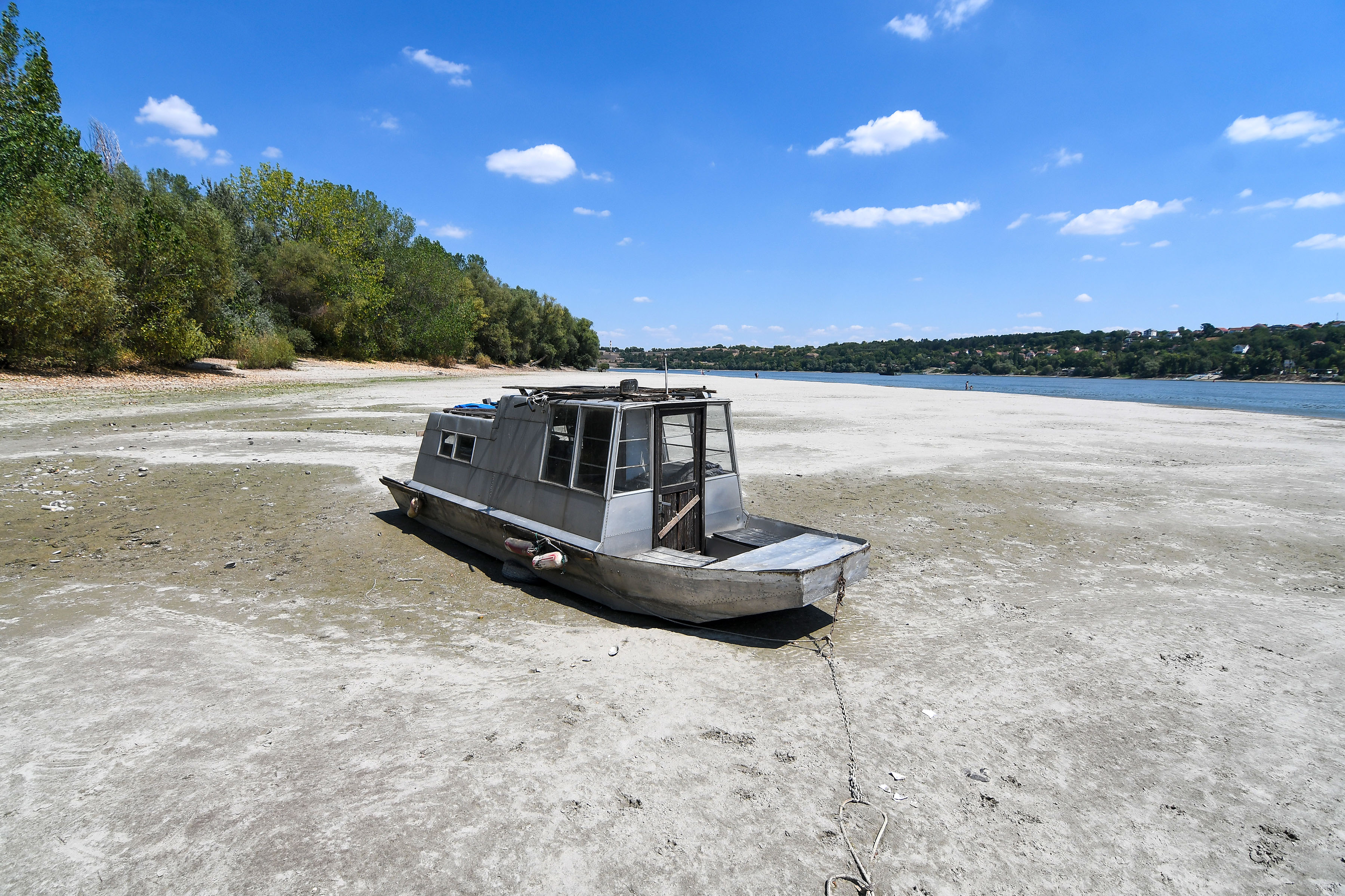 Novi Sad, 2. avgusta 2022. - Nizak vodostaj Dunava kod Novog Sada prouzrokovao je pojavu pescanih sprudova koje su novosadjani iskoristili za uzivanje, kupanje i suncanje. Camac nasukan na pescani sprud. FOTO TANJUG/ NENAD MIHAJLOVIC/ bg