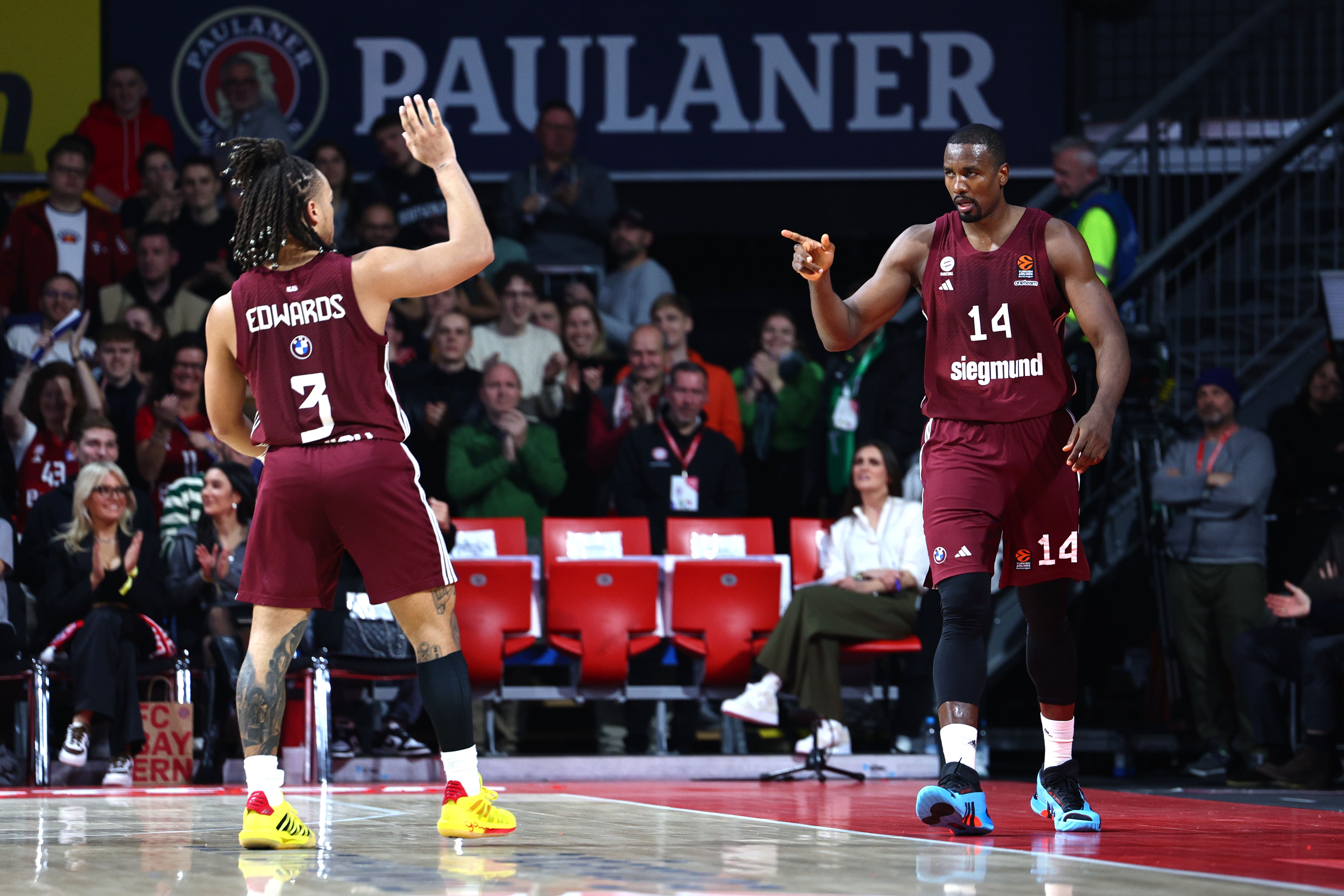 epa11012505 Munichs Carsen Edwards (L) celebrates with Munichs Serge Ibaka (R) during the Euroleague Basketball match between Bayern Munich and Emporio Armani Milan in Munich, Germany, 05 December 2023.  EPA-EFE/ANNA SZILAGYI
