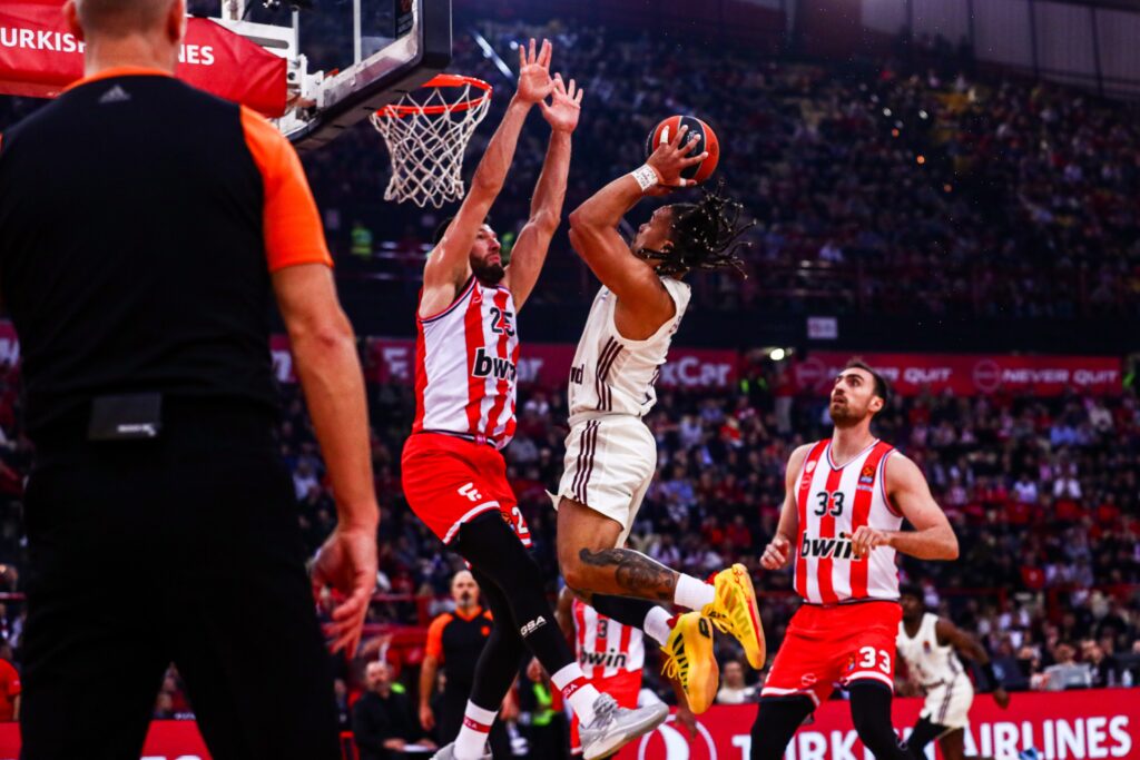 epa11018121 Olympiacos Alec Peters (L) in action against Carsen Edward (2nd-R) of Bayern Munich during the Euroleague basketball match between Olympiacos Piraeus and Bayern Munich, in Piraeus, Greece, 08 December 2023.  EPA-EFE/GEORGIA PANAGOPOULOU