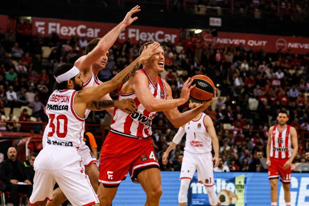 epa11031517 Olympiacos’ Luke Sikma (C) in action against Kassius Robertson (L) of Valencia Basket during the Euroleague basketball match between Olympiacos Piraeus and Valencia Basket, in Piraeus, Greece, 15 December 2023.  EPA-EFE/GEORGIA PANAGOPOULOU