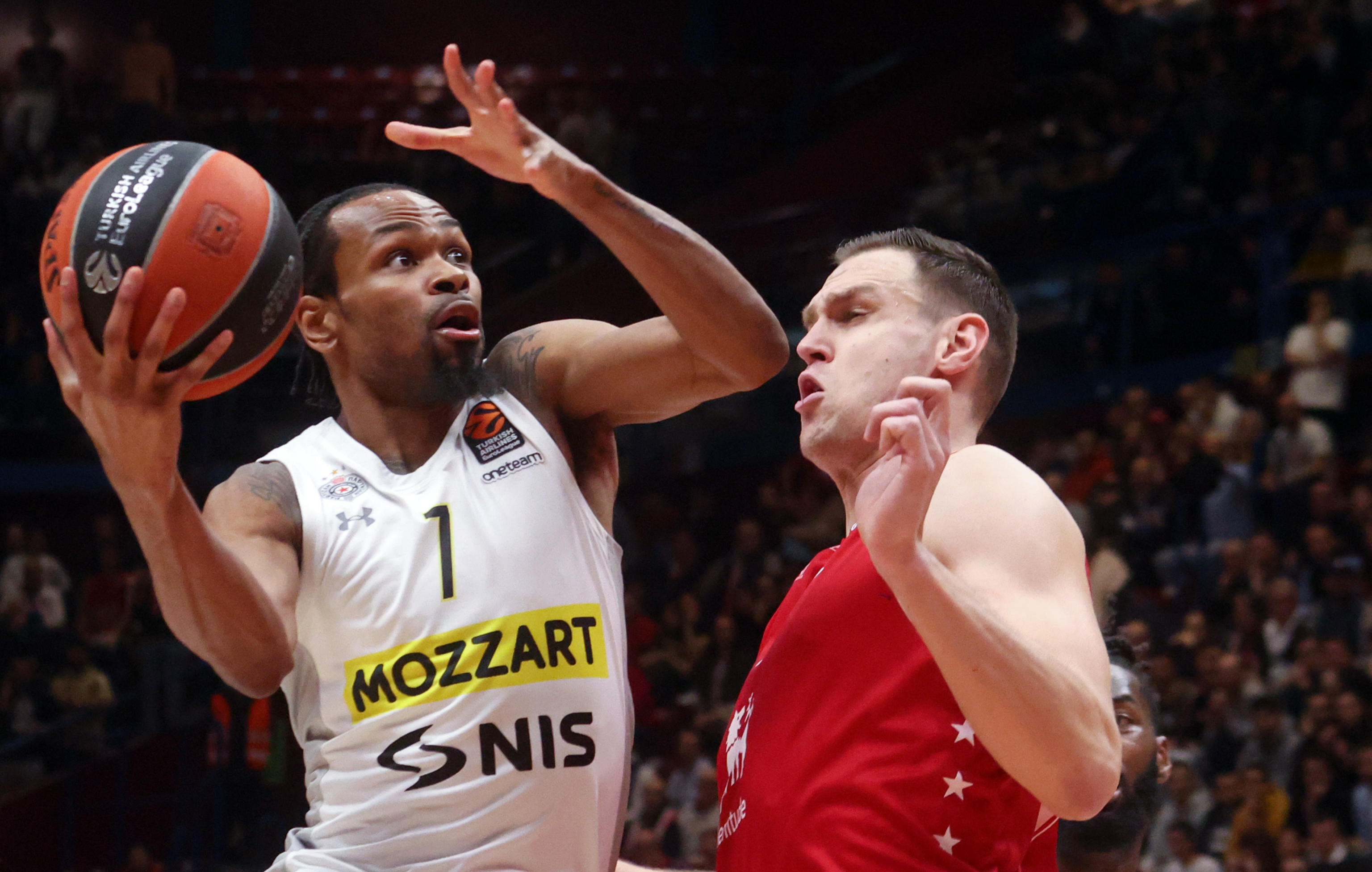 epa10512272 Partizan's Kevin Punter (L) in action against Milan's Johannes Voigtmann during the Euroleague basketball match between EA7 Emporio Armani Milan abd Partizan Mozart Bet Belgrade, in Milan, Italy, 09 March 2023.  EPA-EFE/MATTEO BAZZI