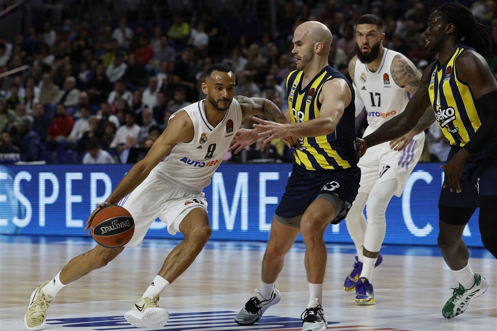 epa10549486 Madrid's Adam Hanga (L) in action against Fenerbahce's Nick Calathes (R) during the Euroleague basketball game between Real Madrid and Fenerbahce Beko at Wizink Center in Madrid, Spain, 29 March 2023.  EPA-EFE/JUANJO MARTIN