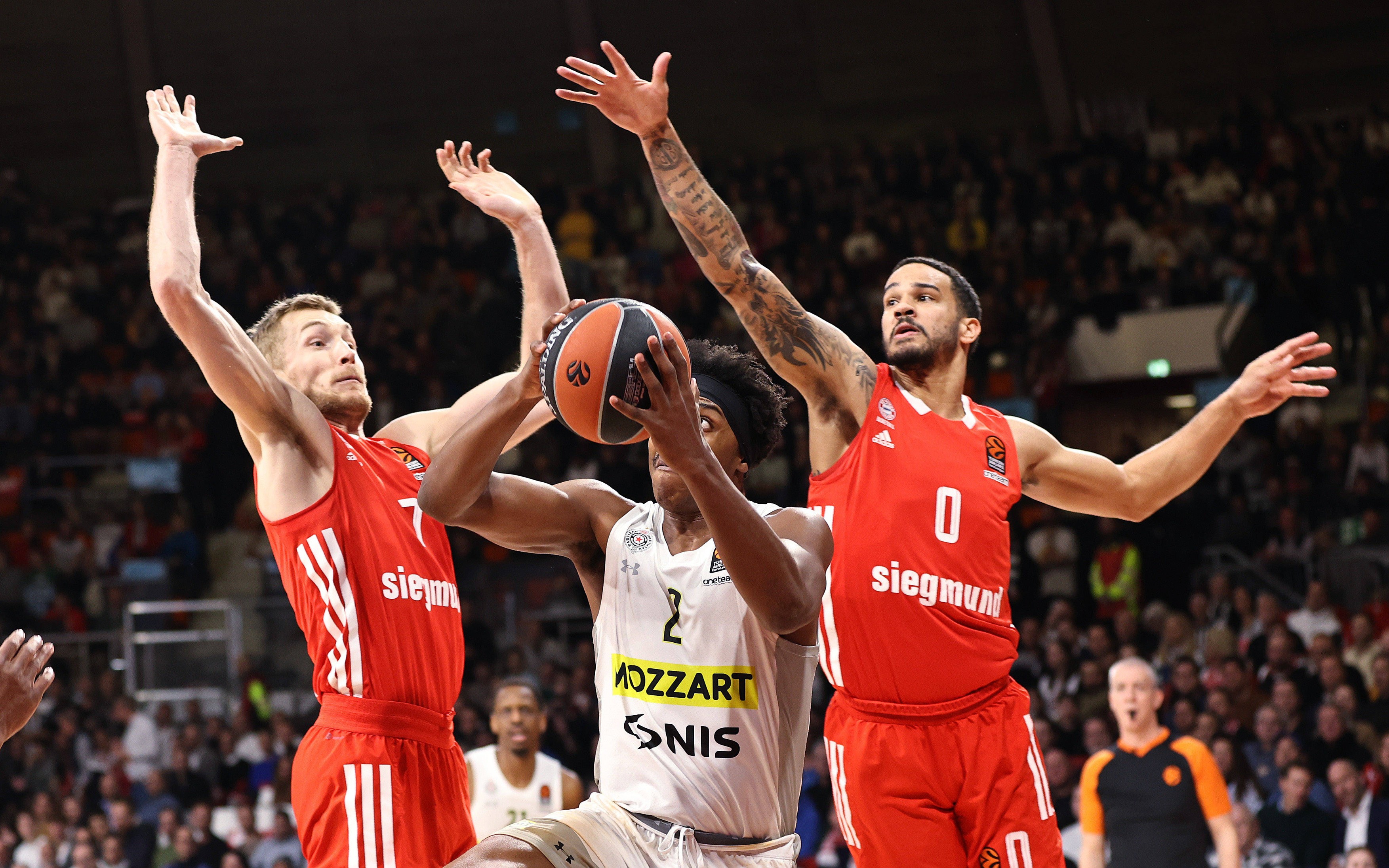 Niels Giffey (Bayern Basketball, 7) und Nick Weiler-Babb (Bayern Basketball, 0) blocken Zach Leday (Partizan Mozzart Bet