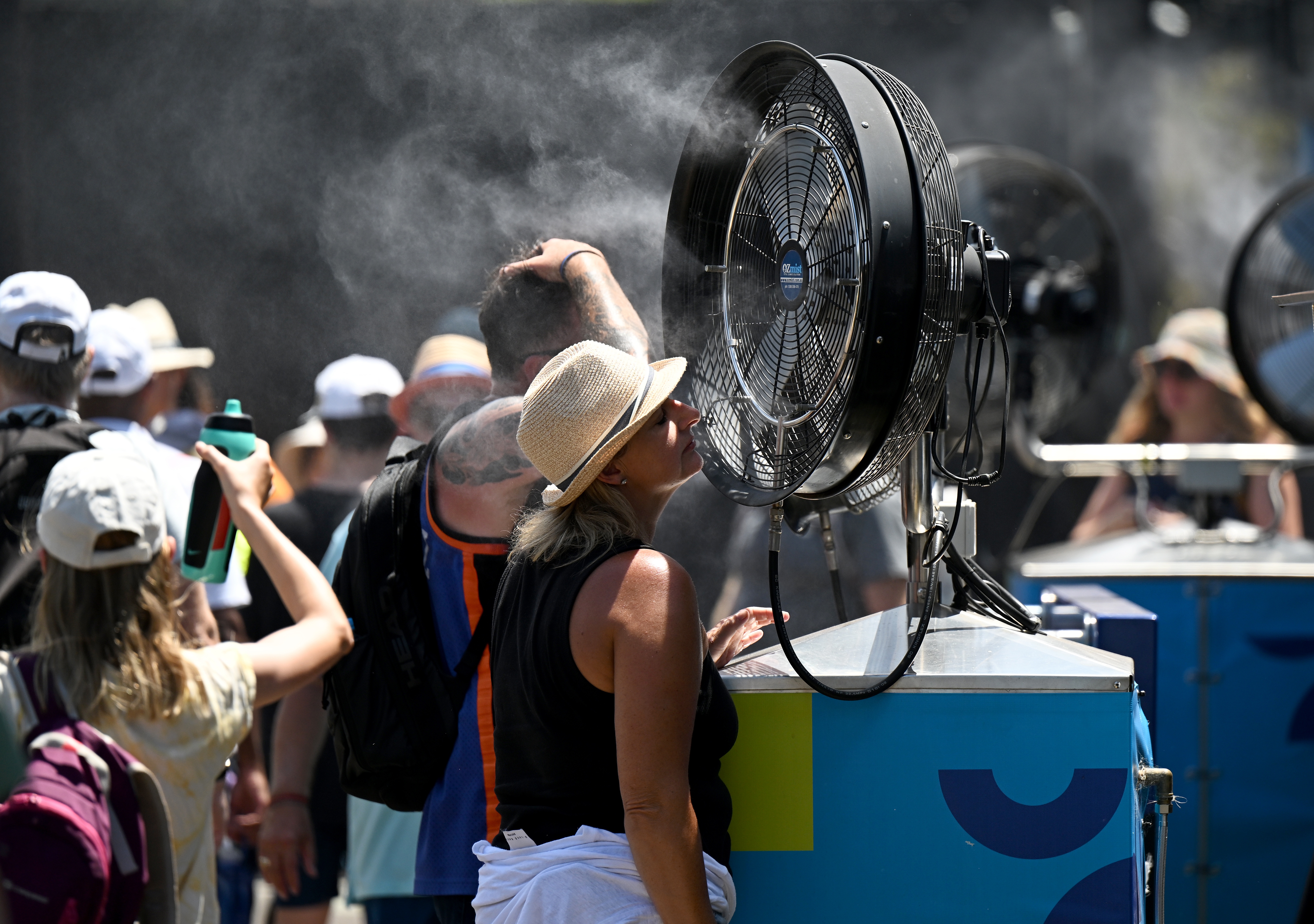 epa10409969 Spectators cool off during the 2023 Australian Open tennis tournament at Melbourne Park in Melbourne, Australia, 17 January 2023.  EPA-EFE/LUKAS COCH  AUSTRALIA AND NEW ZEALAND OUT