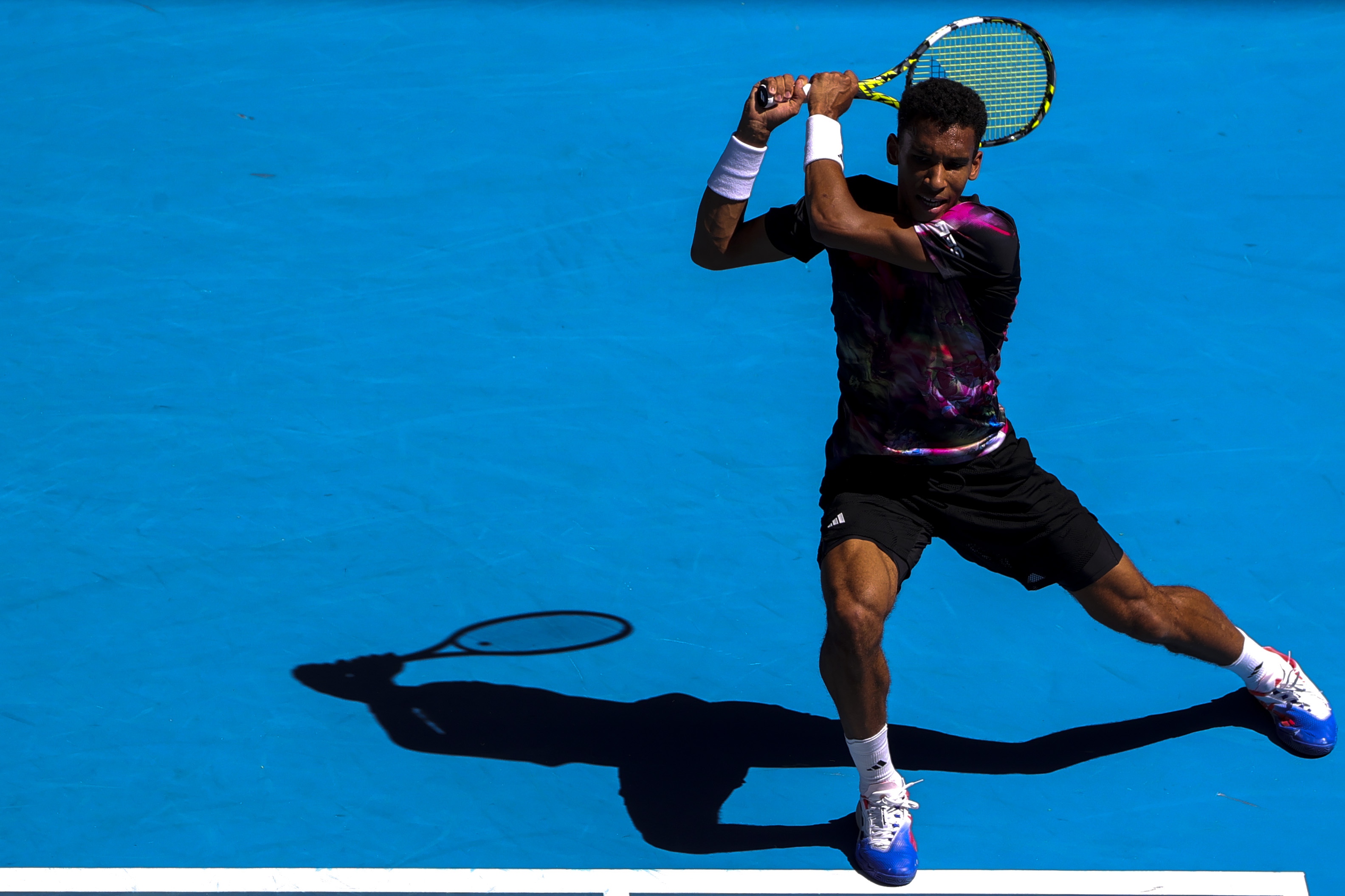 epa10417074 Felix Auger-Aliassime of Canada in action against Francisco Cerundolo of Argentina during their third round match at the Australian Open tennis tournament in Melbourne, Australia 20 January 2023.  EPA-EFE/FAZRY ISMAIL