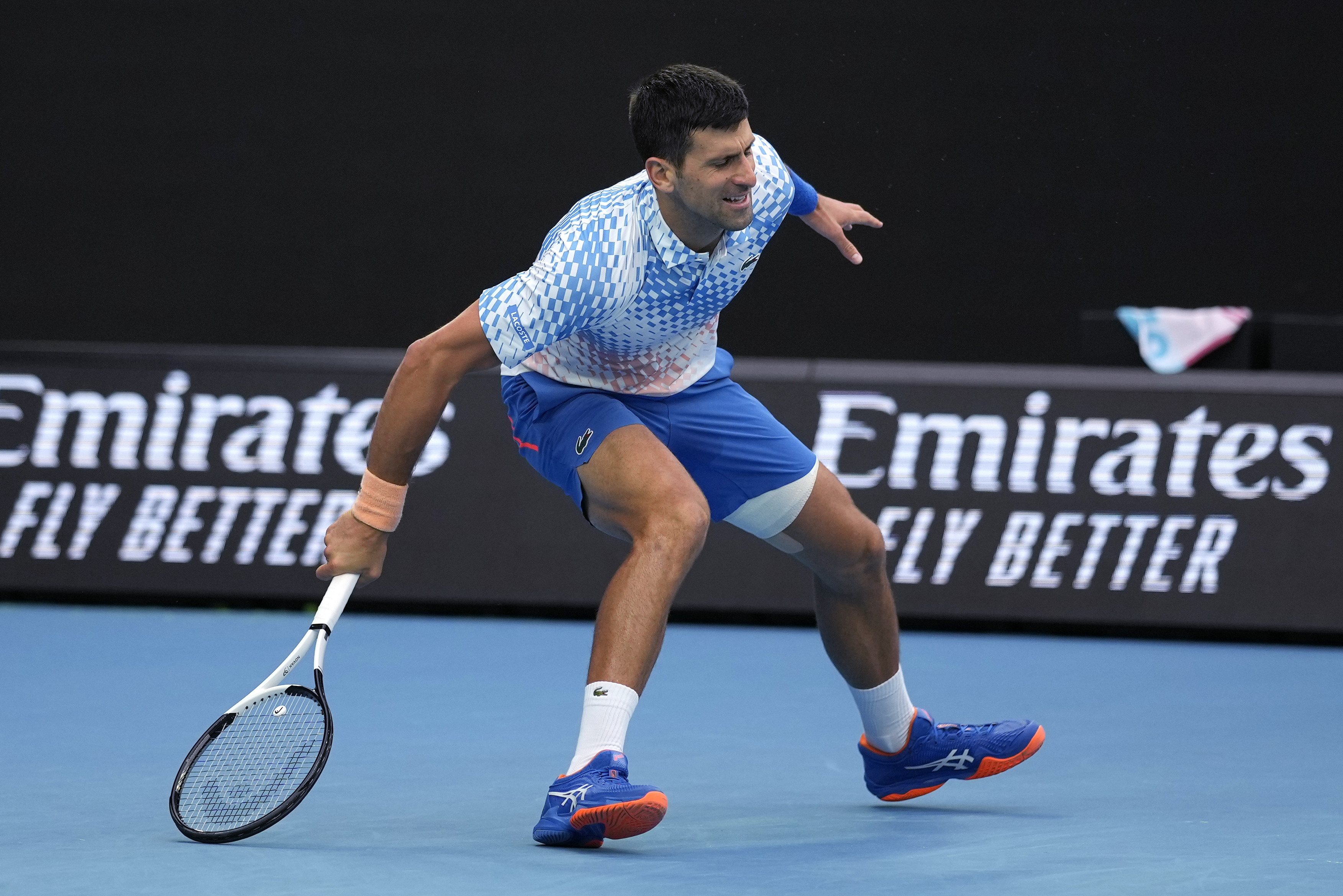 Novak Djokovic of Serbia stumbles as he attempts to make a return to Grigor Dimitrov of Bulgaria during their third round match at the Australian Open tennis championship in Melbourne, Australia, Saturday, Jan. 21, 2023. (AP Photo/Aaron Favila)
