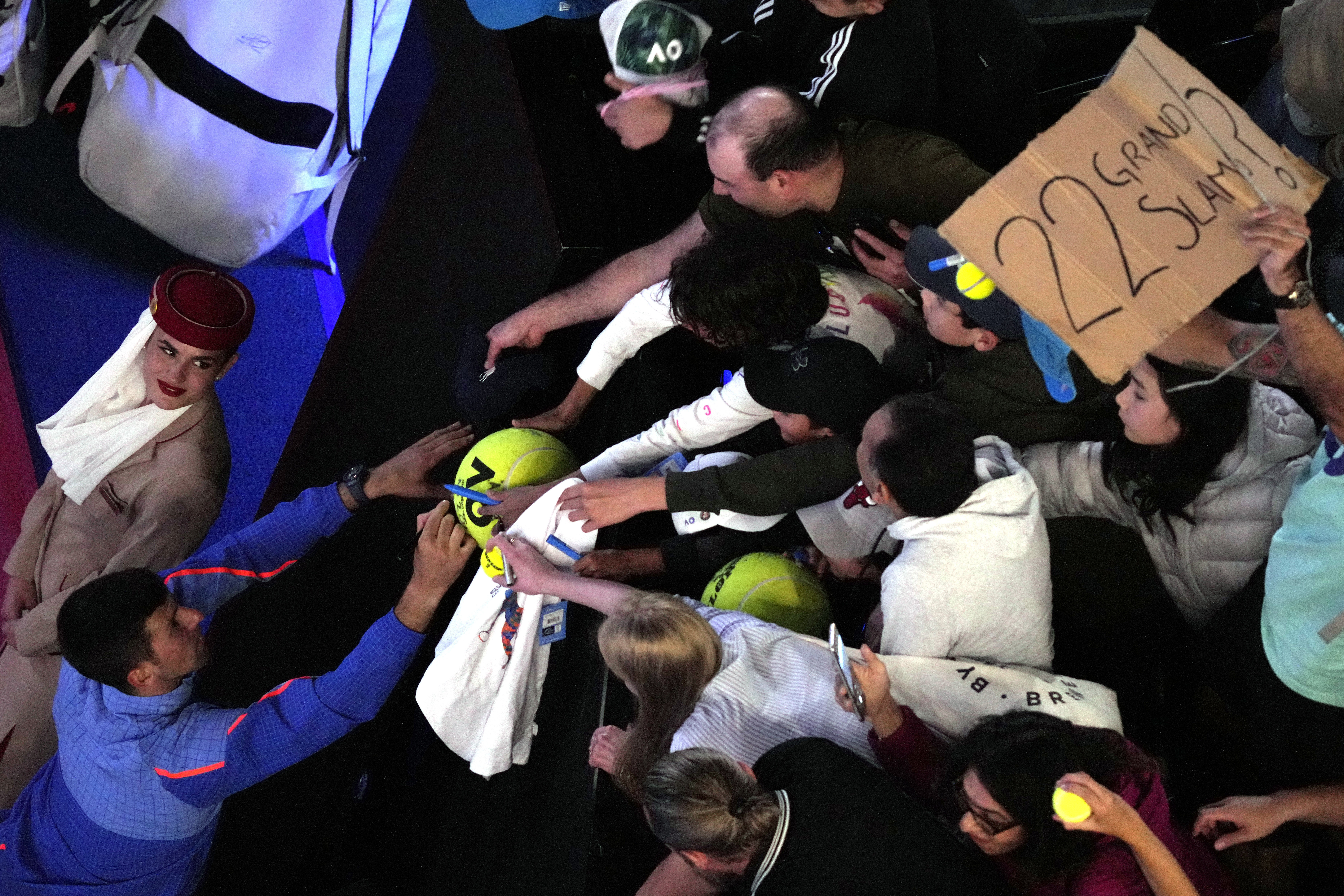 Novak Djokovic of Serbia signs autographs after his third round match against Grigor Dimitrov of Bulgaria at the Australian Open tennis championship in Melbourne, Australia, Saturday, Jan. 21, 2023. (AP Photo/Dita Alangkara)