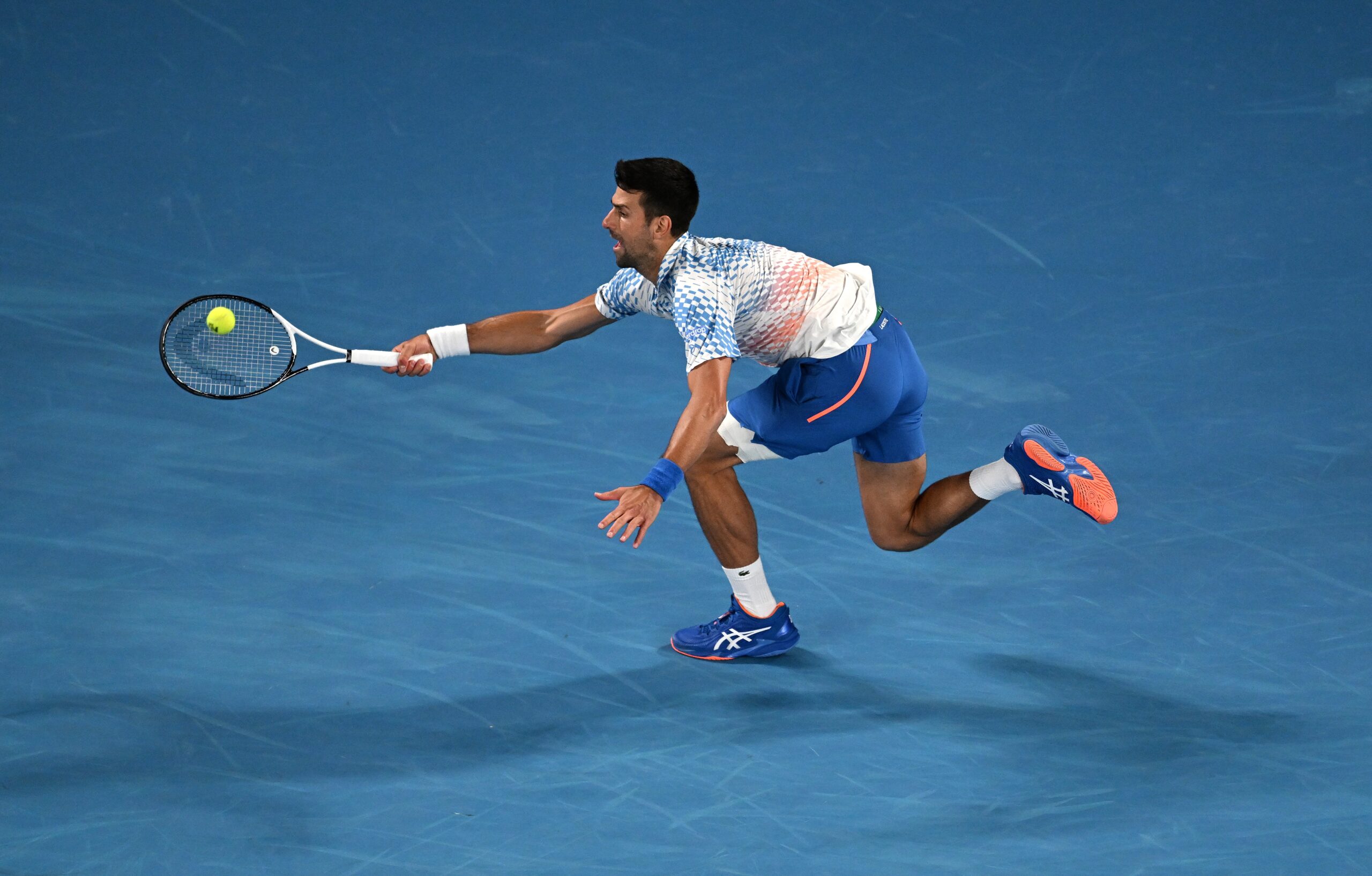 epa10415282 Novak Djokovic of Serbia returns to Enzo Couacaud of France during their second round match at the 2023 Australian Open tennis tournament in Melbourne, Australia, 19 January 2023.  EPA-EFE/LUKAS COCH  AUSTRALIA AND NEW ZEALAND OUT