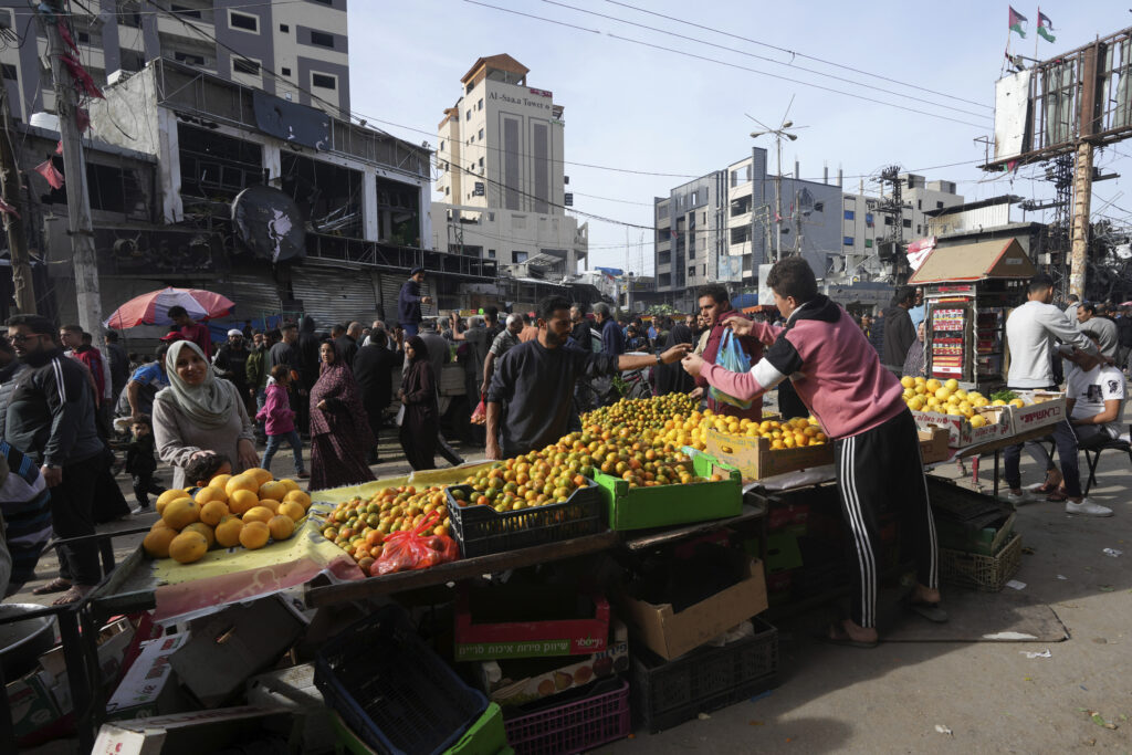 Palestinians visit an open-air market in Nusseirat refugee camp, central Gaza Strip, on Saturday, Nov. 25, 2023. on the second day of the temporary ceasefire between Hamas and Israel. (AP Photo/Adel Hana)