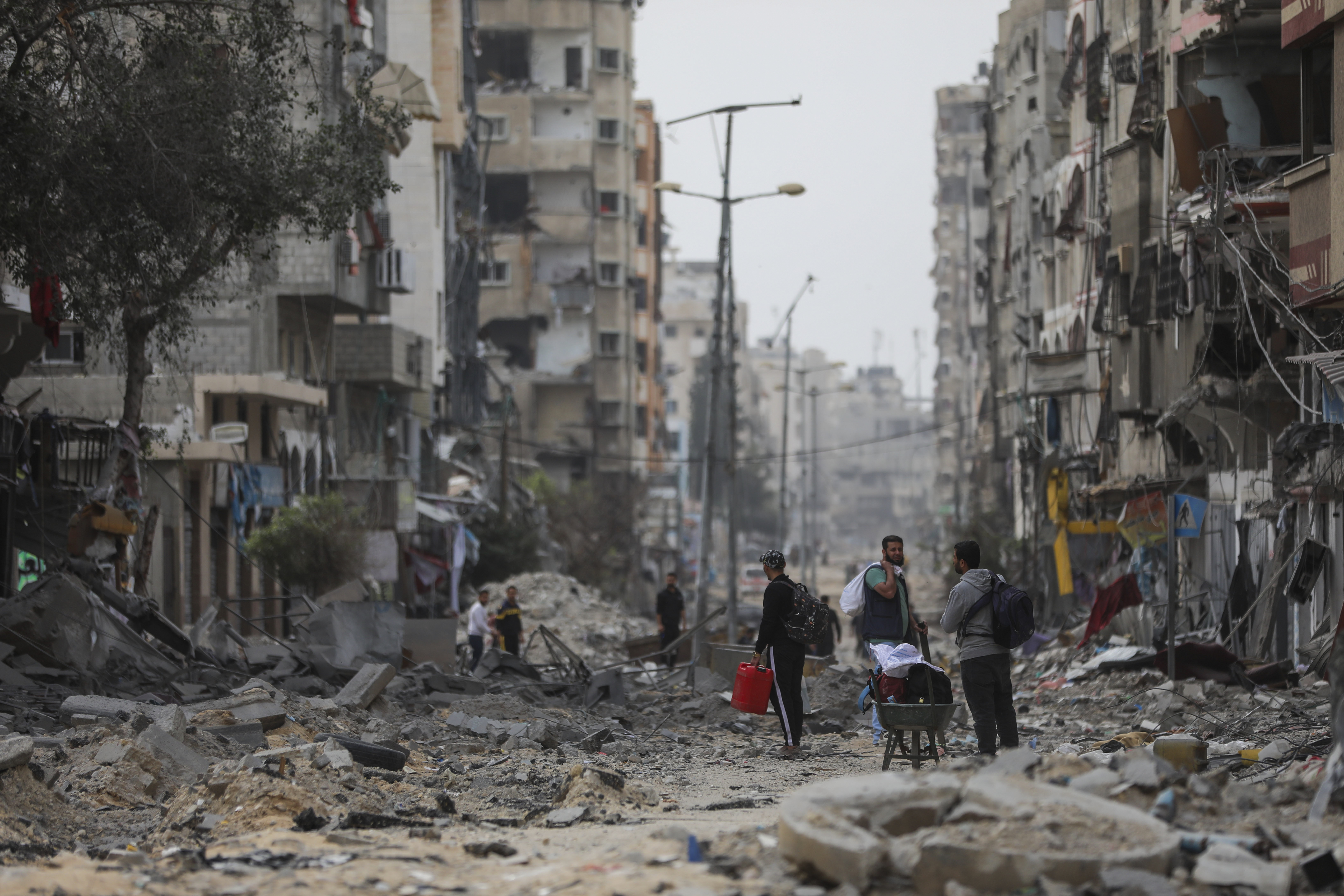 Palestinians walk through destruction in Shati refugee camp on Saturday, Nov. 25, 2023. on the second day of the temporary ceasefire between Hamas and Israel. (AP Photo/Mohammed Hajjar)