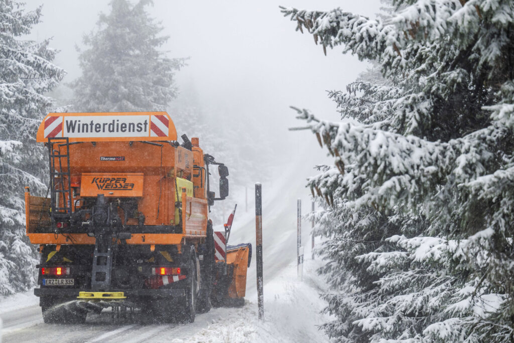 A winter service vehicle clears the snow-covered Fichtelberg road up to Saxony's highest peak, in Oberwiesenthal, Germany, Saturday, Nov. 11, 2023. (Kristin Schmidt/dpa via AP)