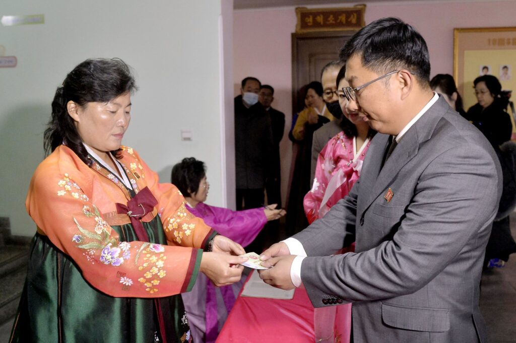 A woman hands a ballot to a man at a polling station in Pyongyang on Nov. 26, 2023, for a local assembly election.,Image: 824557865, License: Rights-managed, Restrictions: , Model Release: no, Credit line: Kyodo/Newscom / Newscom / Profimedia
